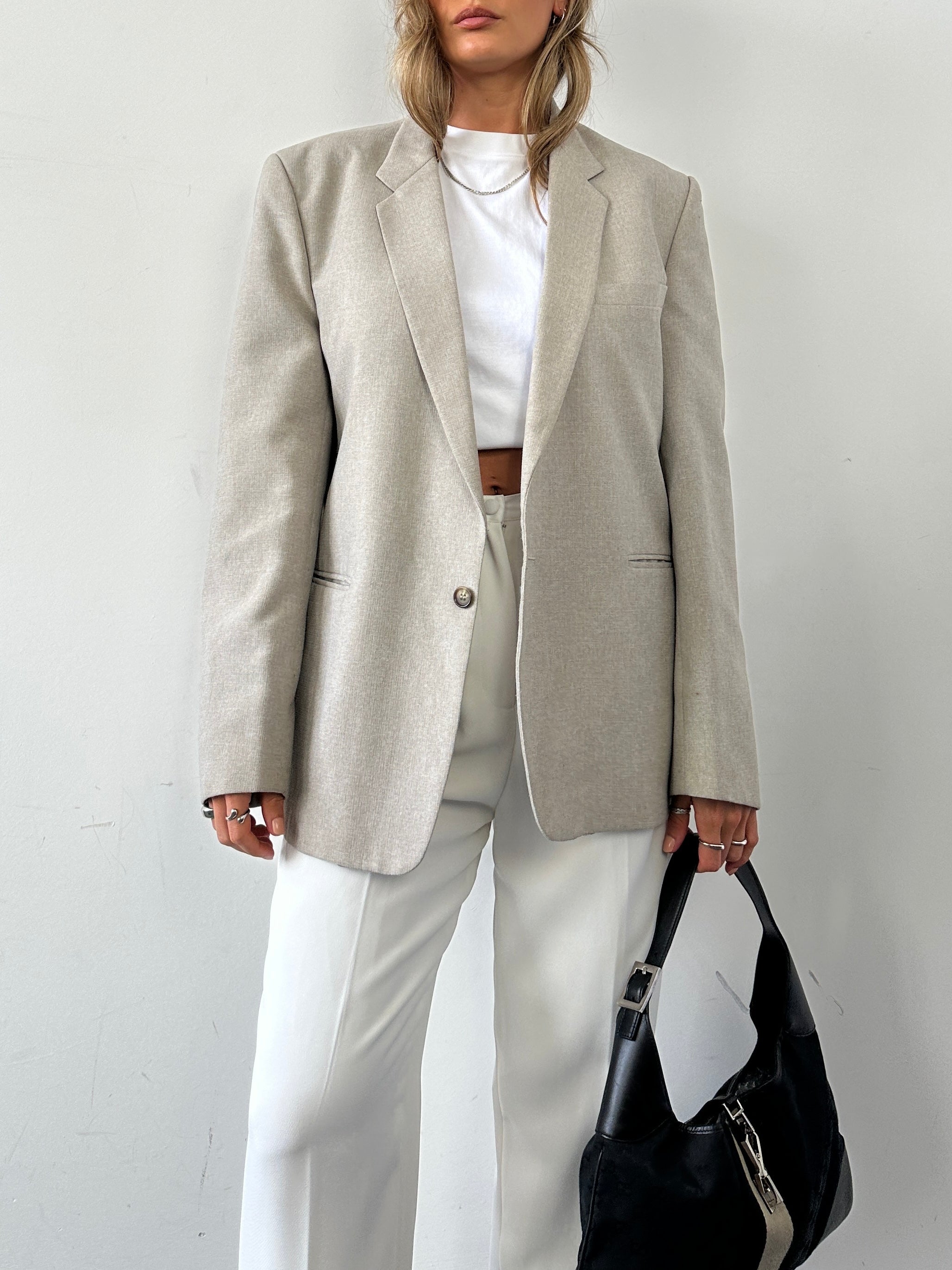 Vintage British vintage minimal blazer in size L, tailored fit with classic lapels and sleek design, shown on a hanger.