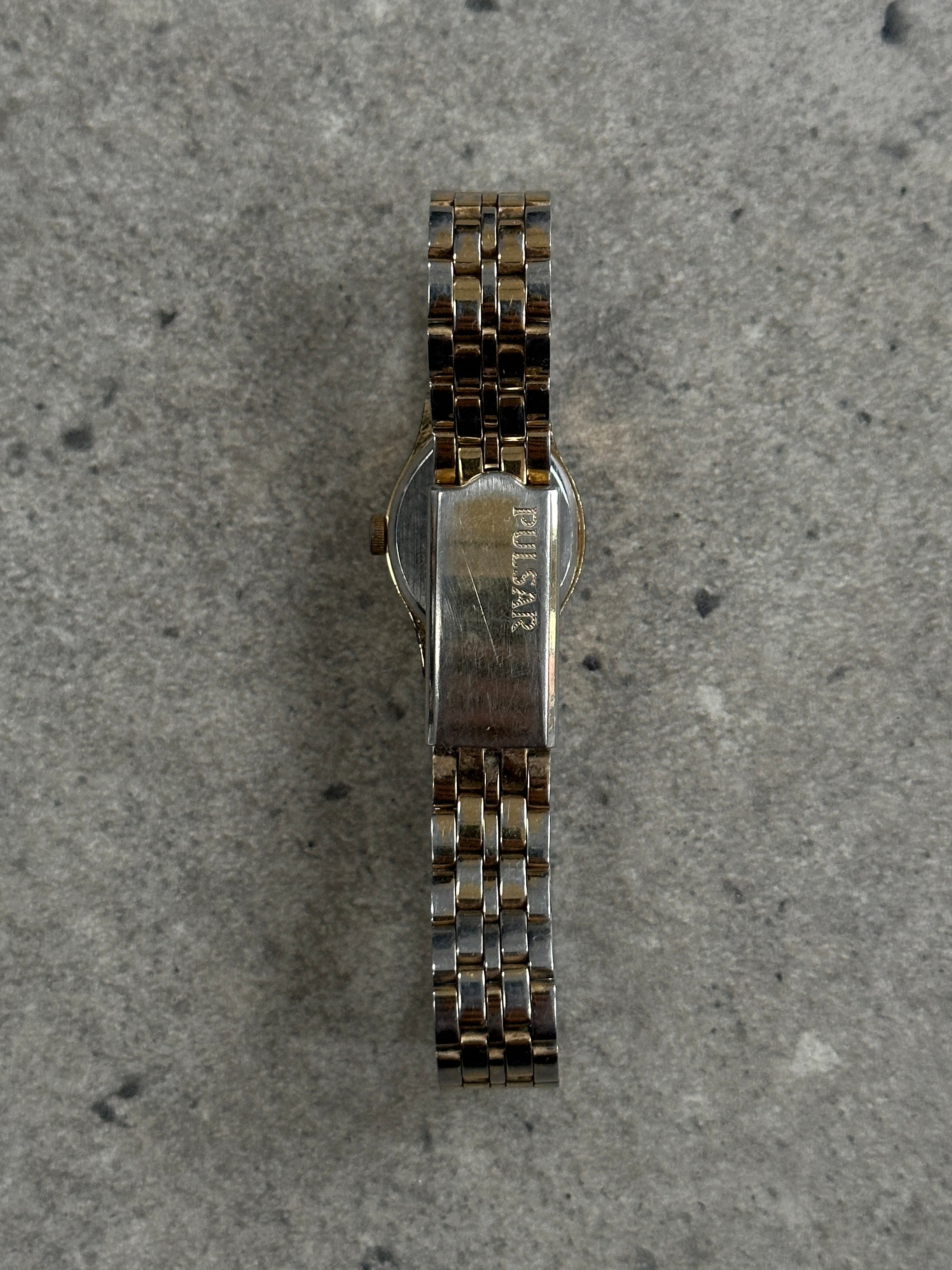 Pulsar 1990s two-tone round quartz watch with silver and gold accents, classic design, and analog display.