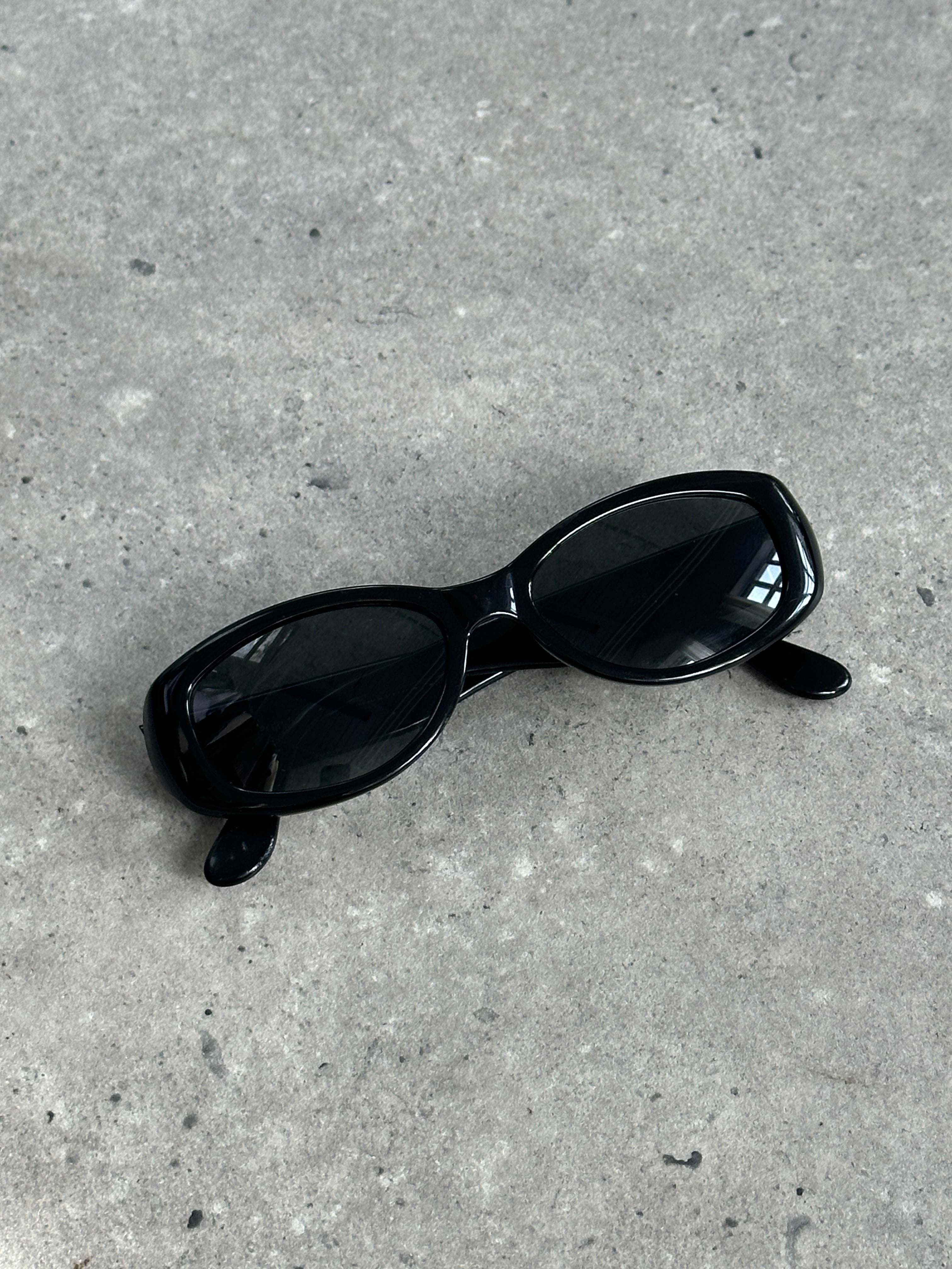 Emporio Armani oval sunglasses with black frames and dark lenses, stylish and modern eyewear for men and women.