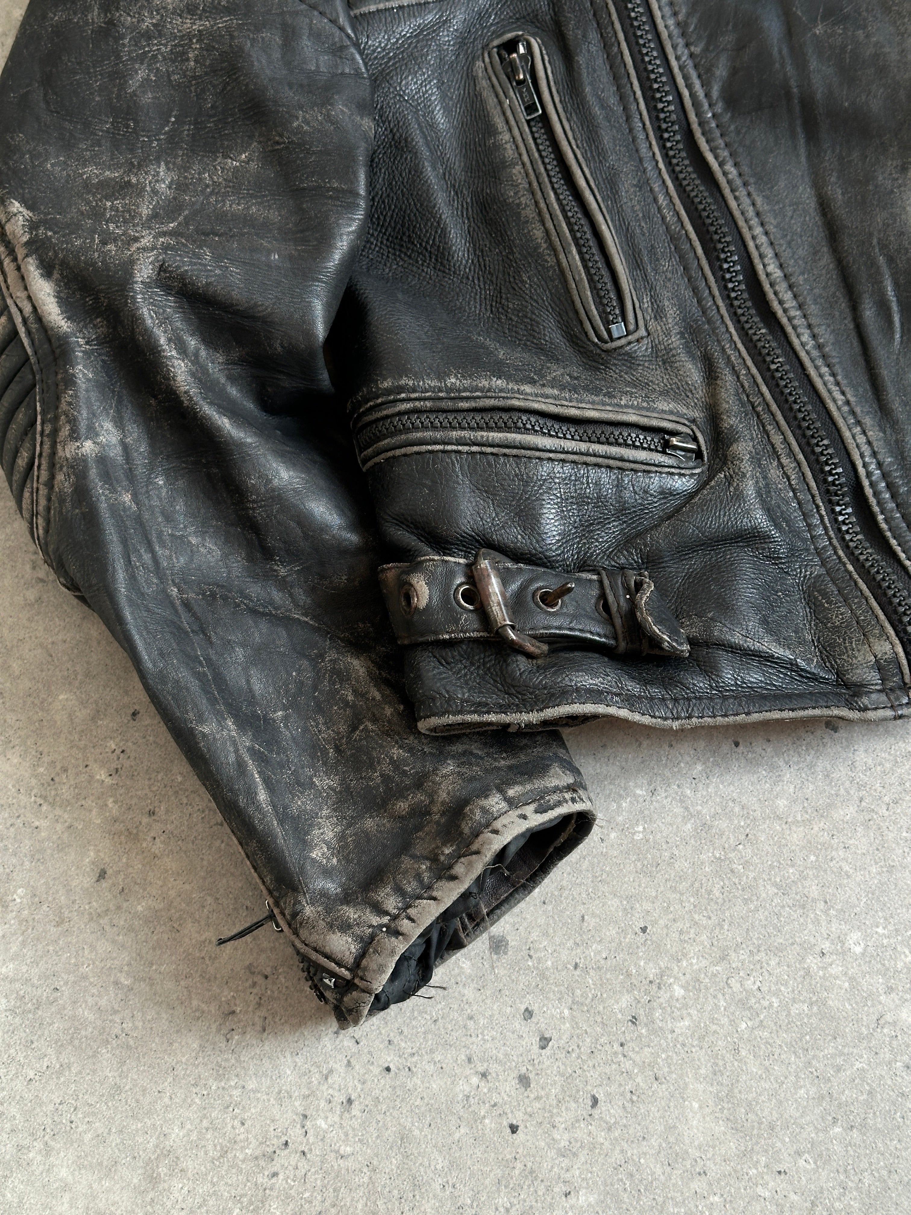 Vintage brand distressed leather motorcycle jacket in size M/L, featuring rugged, vintage-style detailing and classic motorcycle jacket design.