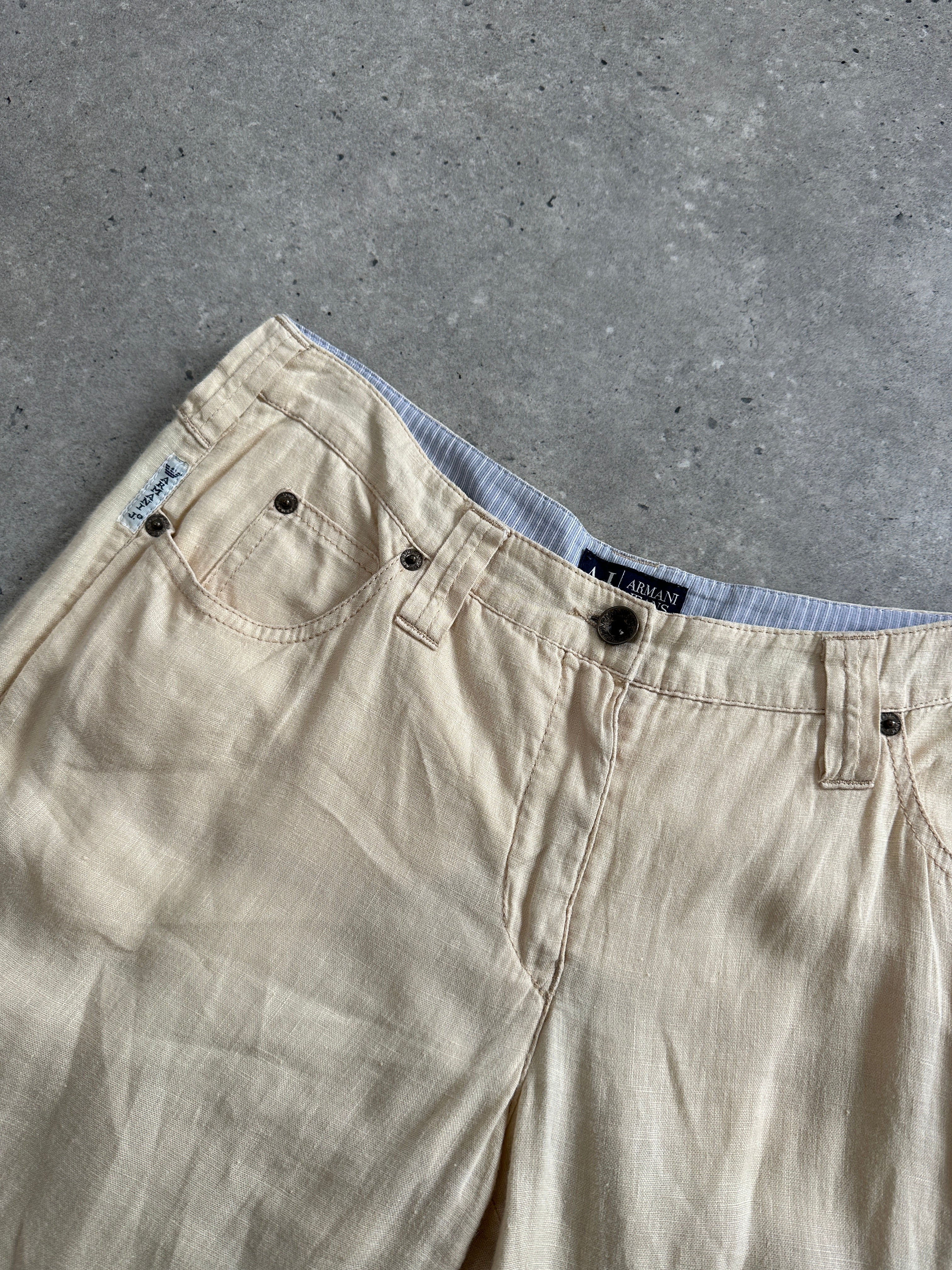 Armani Jeans low rise pure linen flared trousers in W29 laid flat, showcasing their light fabric and stylish design.