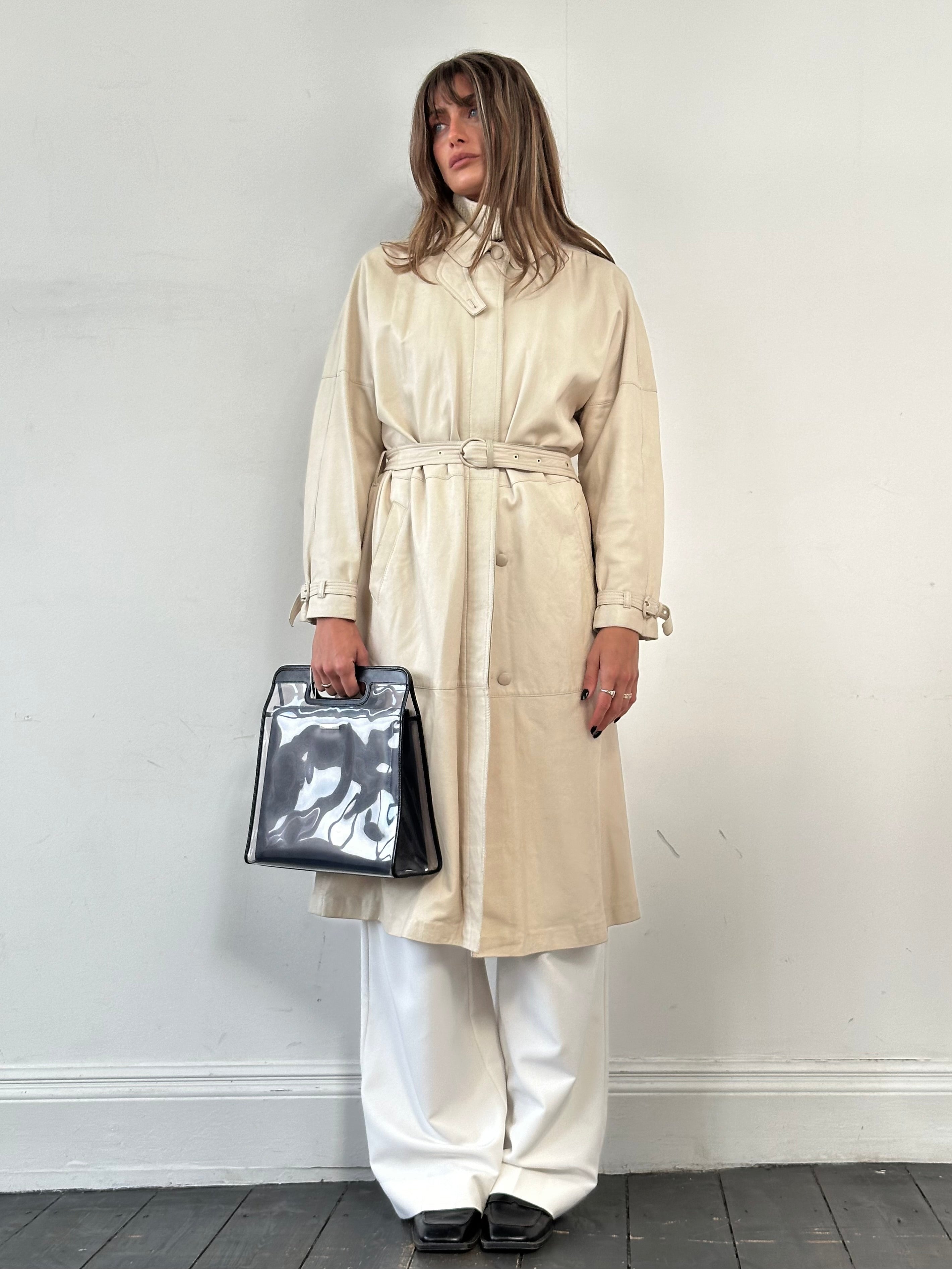 Vintage leather trench coat with belt, tailored fit, visible stitching, and classic design, perfect for a stylish vintage look.