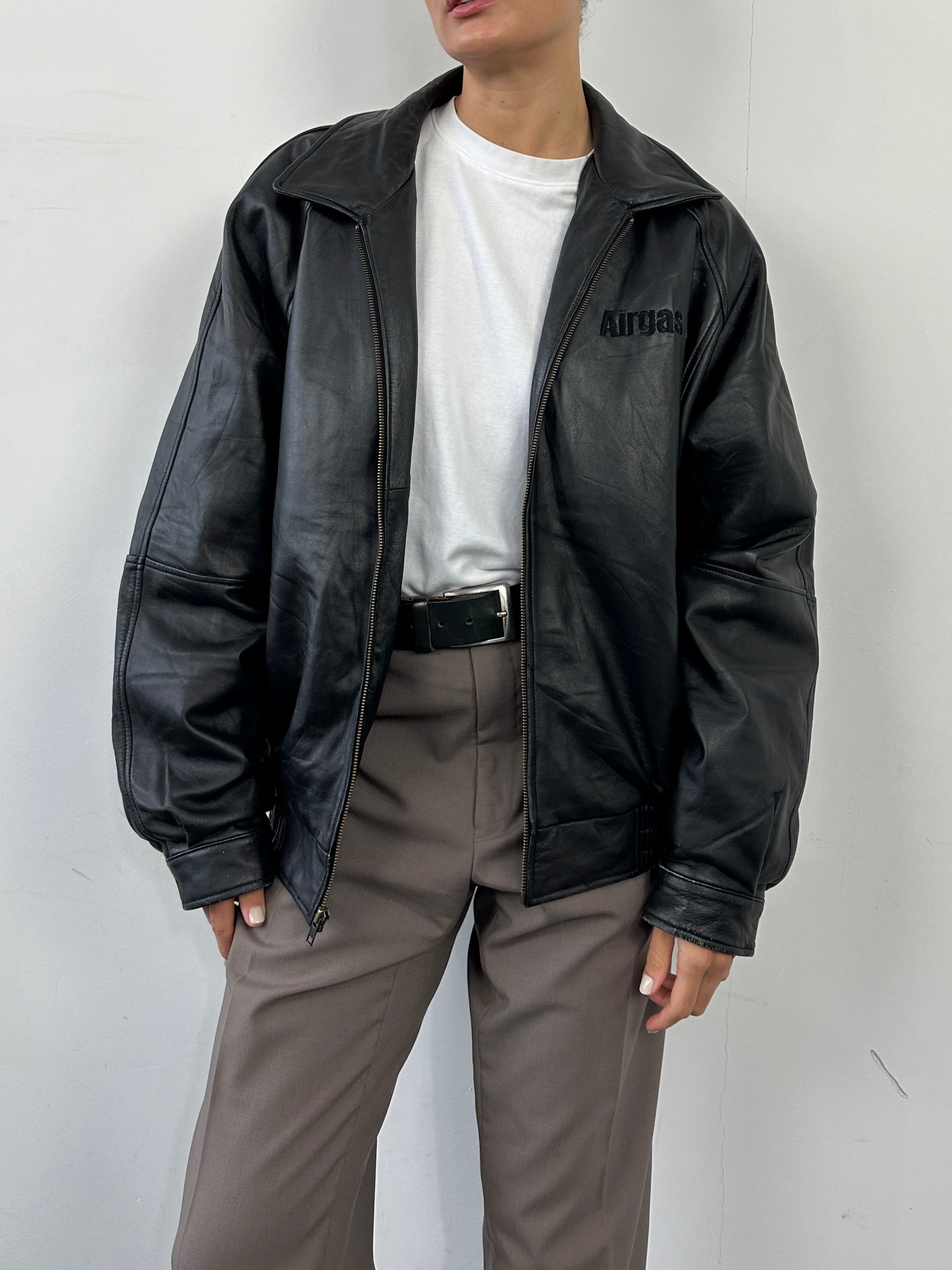 Vintage leather bomber jacket with intricate embroidery, in size L/XL, showcasing detailed craftsmanship and classic style.