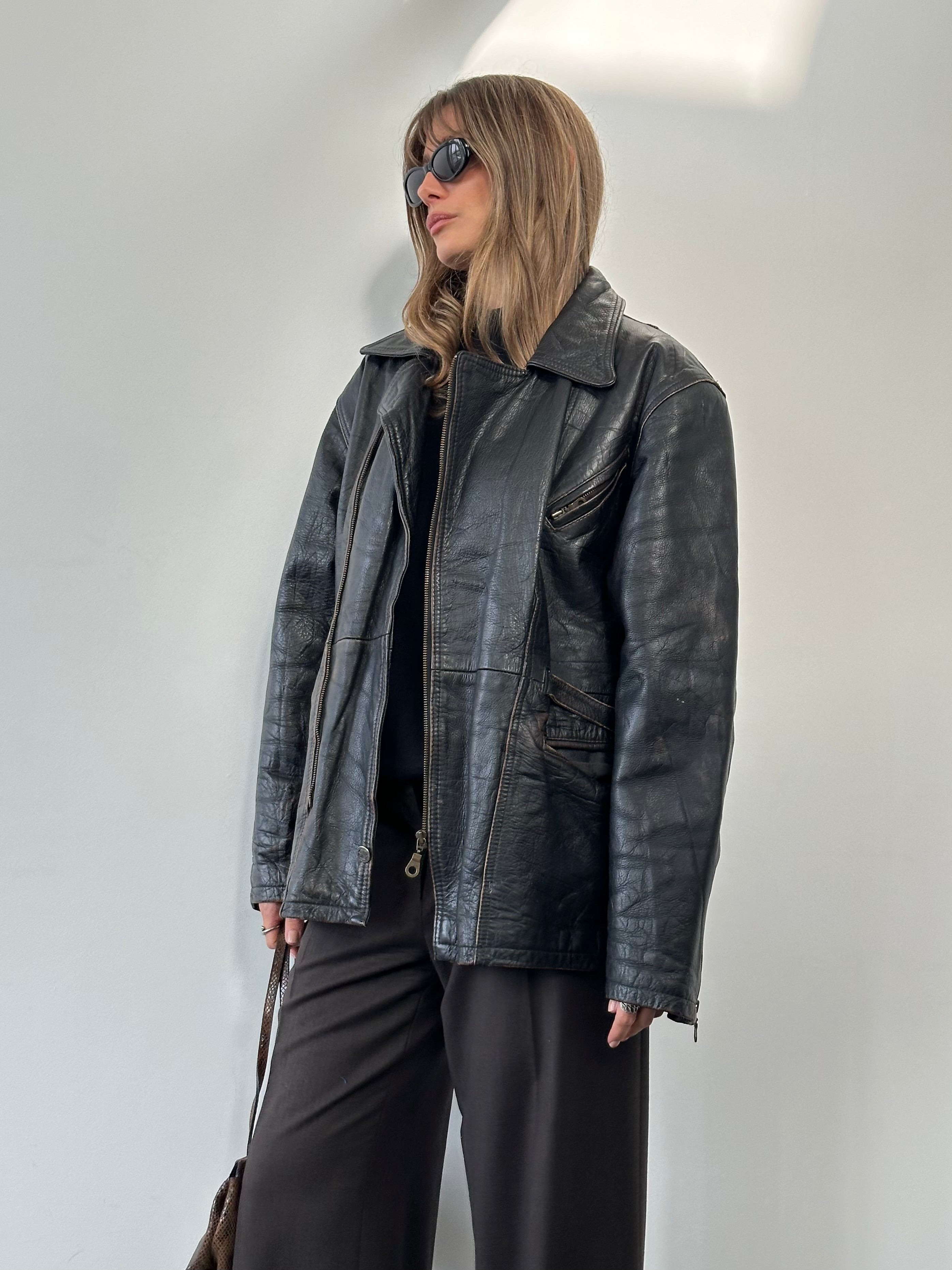 Vintage distressed leather jacket in XL size, featuring rugged style and classic design, shown on a hanger.