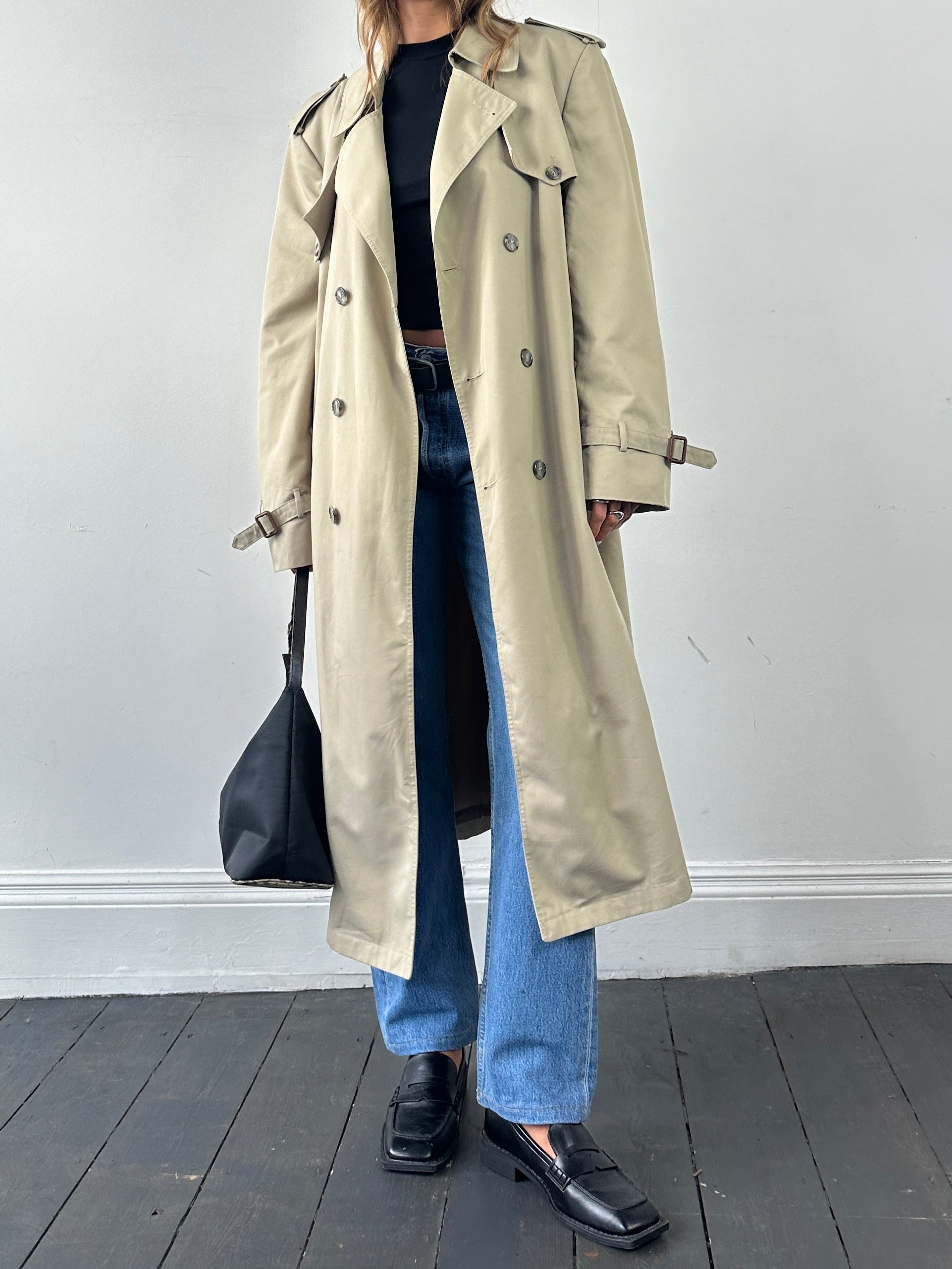 Christian Dior double-breasted belted trench coat in XL, shown hanging with classic beige fabric and stylish belt detail.
