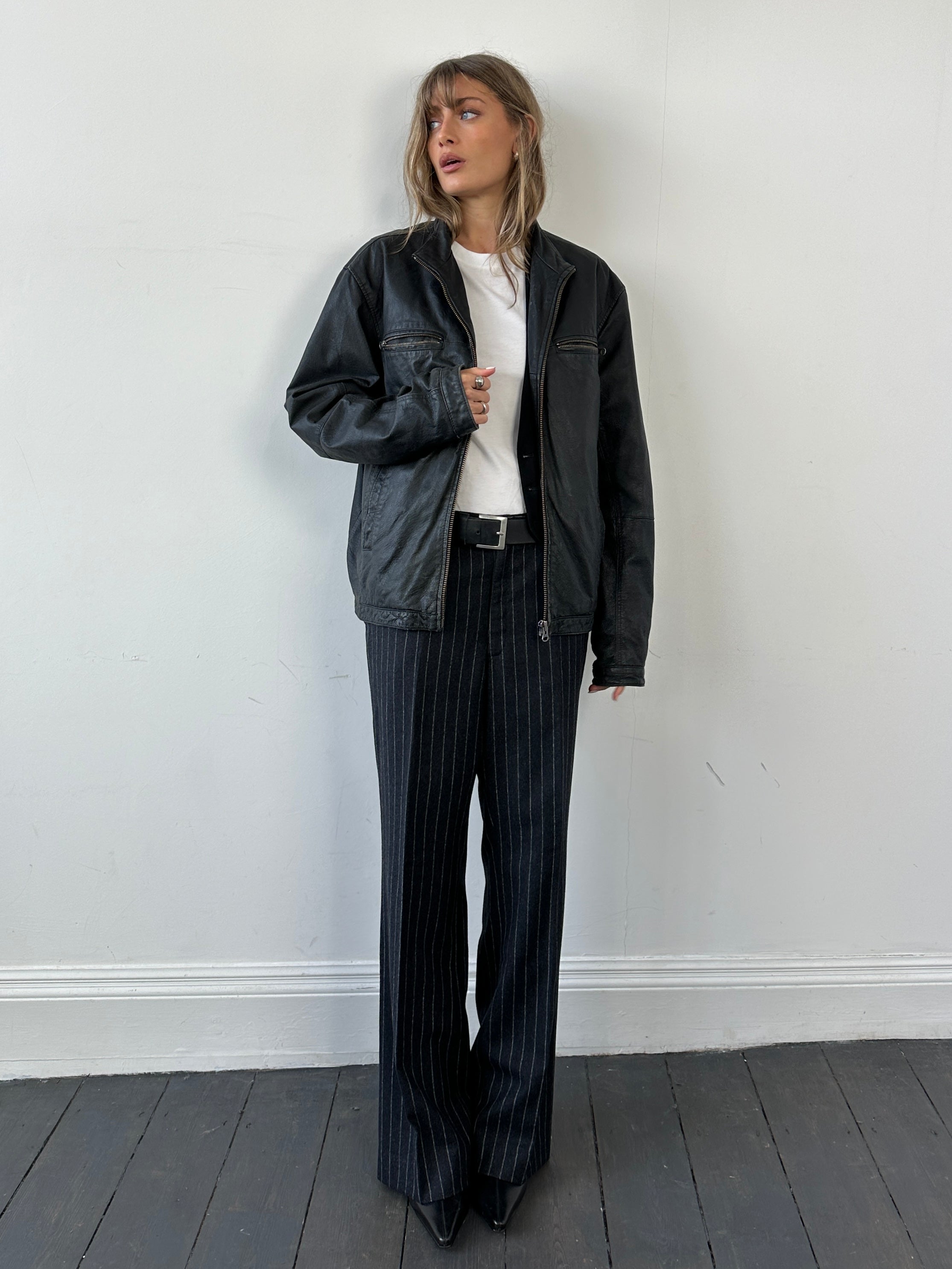 Vintage leather zip-up jacket in size large, featuring classic design and durable material, displayed on a hanger.