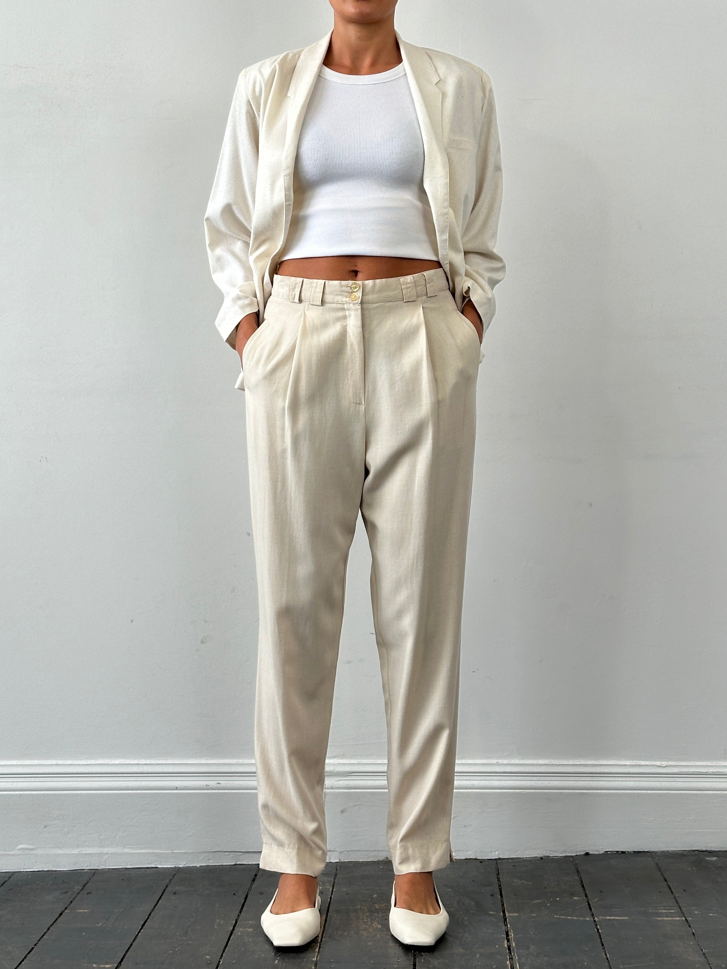 Vintage high-waisted tailored pleated trousers in W28, featuring classic design and structured fit, shown on a neutral background.