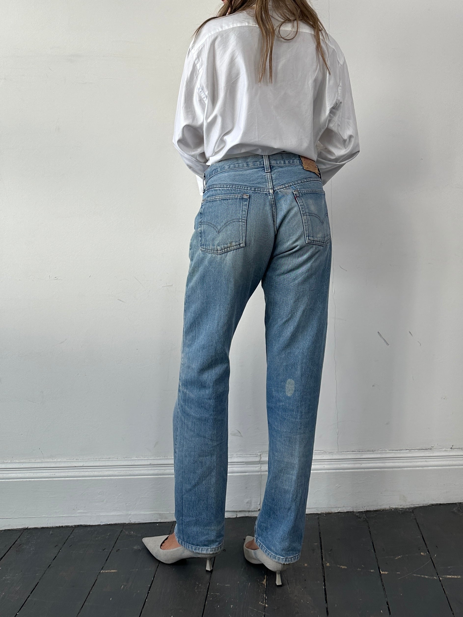 Levi's 501 straight leg denim jeans in W32, showcasing classic blue denim with a button fly and five-pocket design.