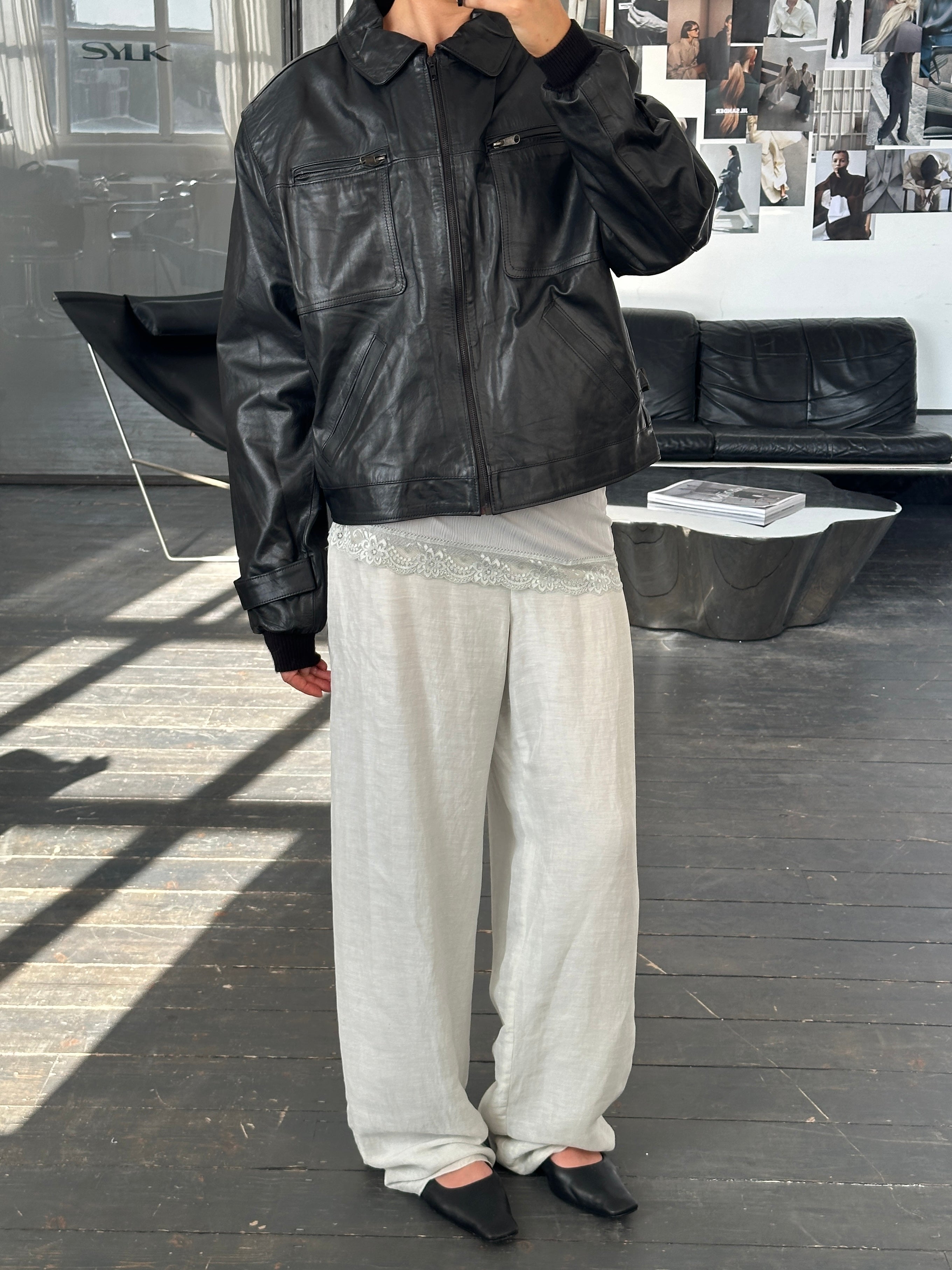 Vintage 1990s boxy cropped leather jacket in black, featuring classic style and textured leather details.