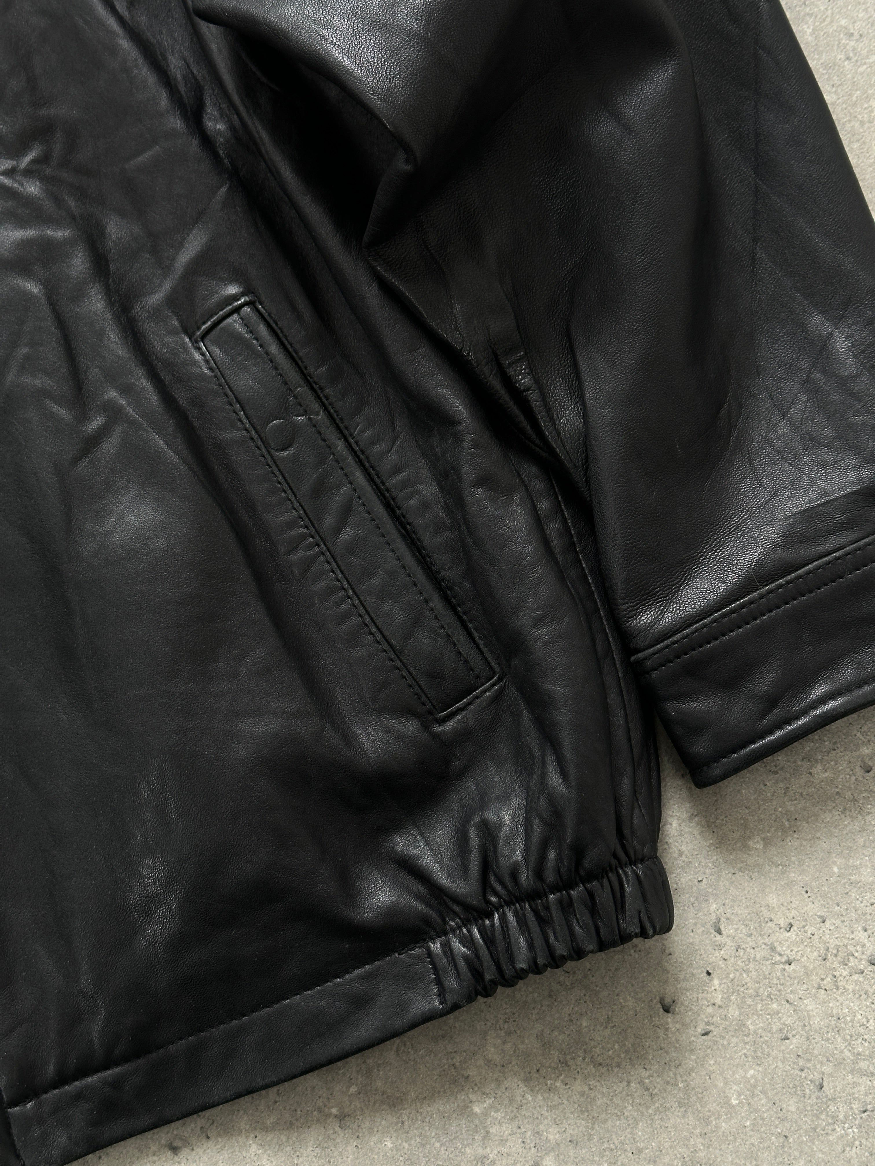 Vintage minimal leather jacket in size L/XL, featuring sleek design and classic craftsmanship, displayed on a plain background.