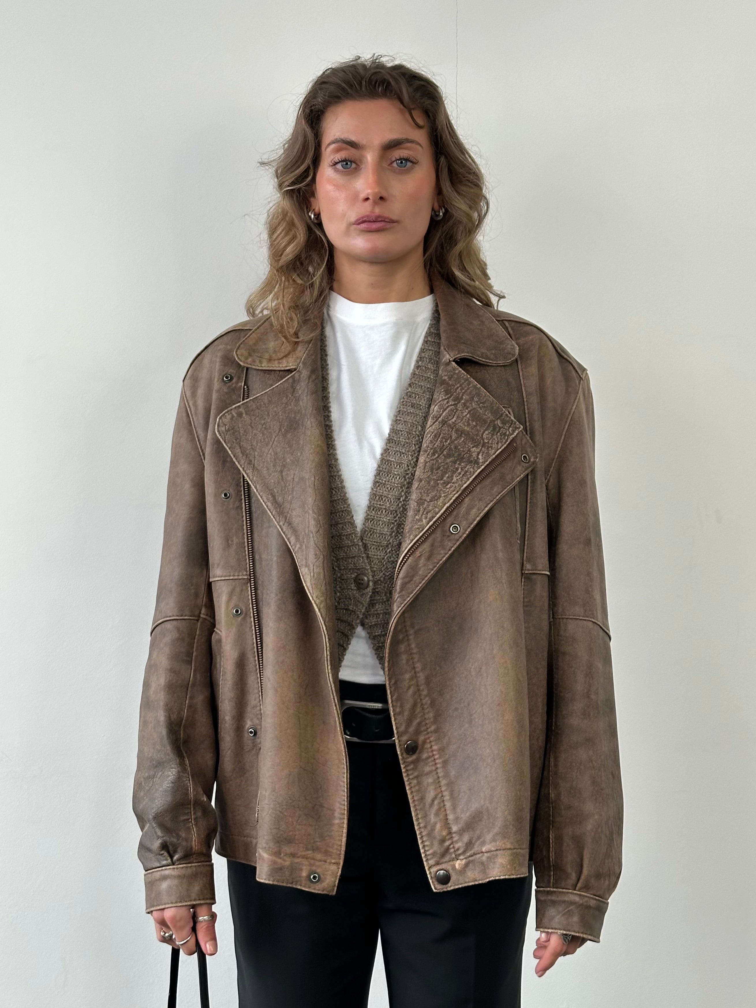 Vintage British aged leather biker jacket in size M/L with classic design and rugged finish, perfect for vintage style apparel.