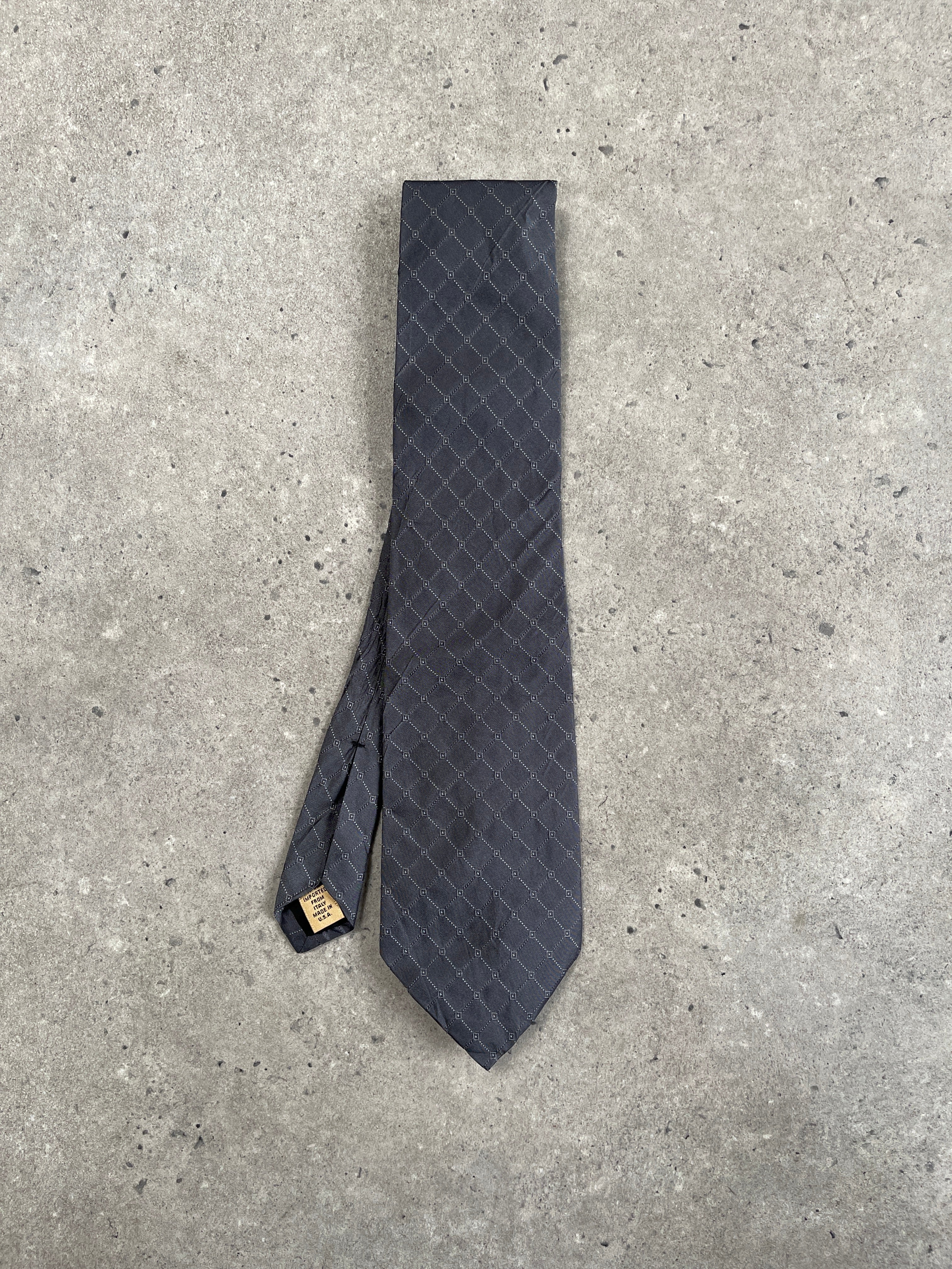Donna Karan Signature 1990s pure silk print tie draped on a hanger with intricate floral pattern and vibrant colors.