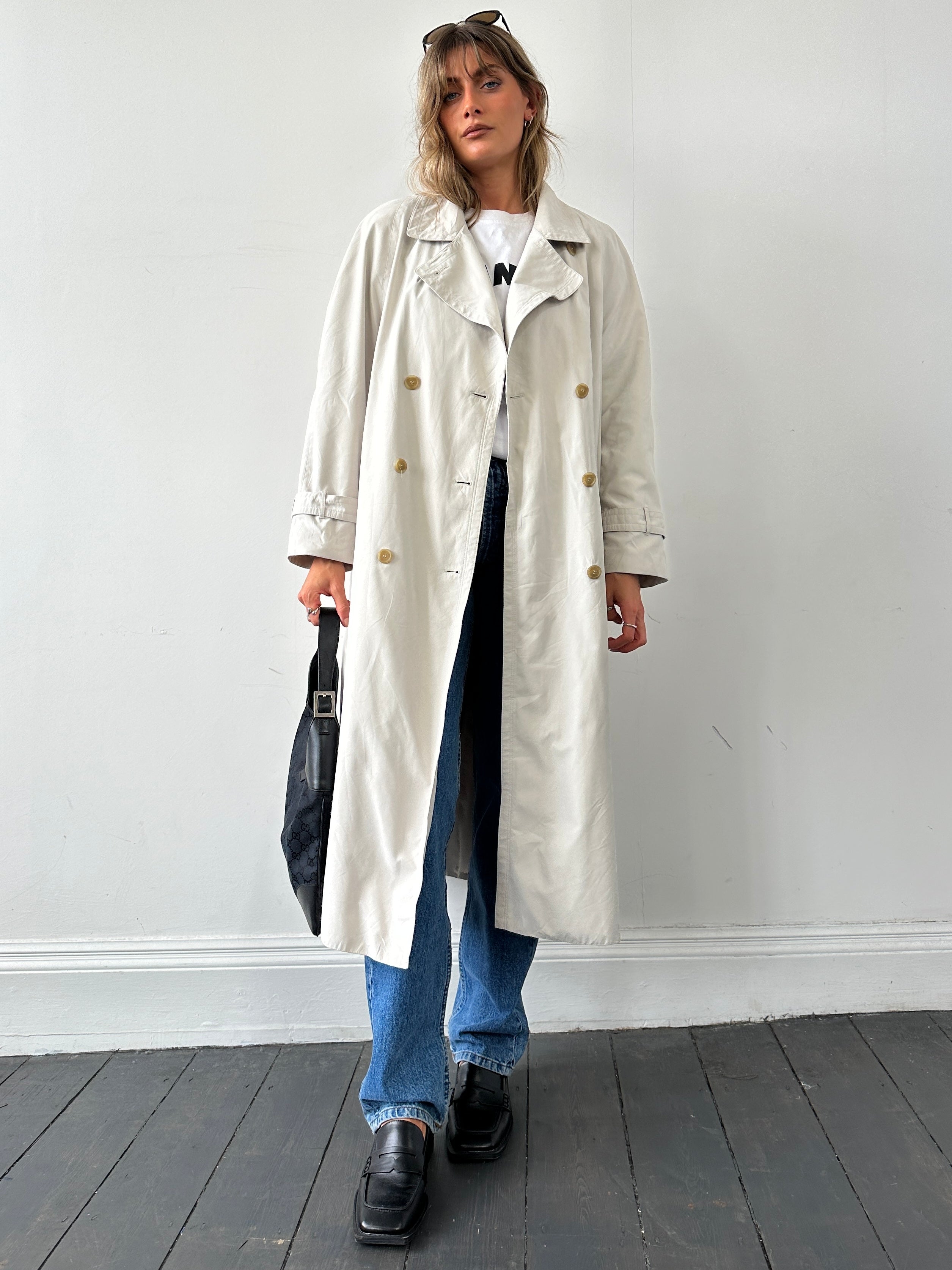 Vintage brand vintage floor length trench coat in size large, classic beige color, showing its stylish, timeless design.