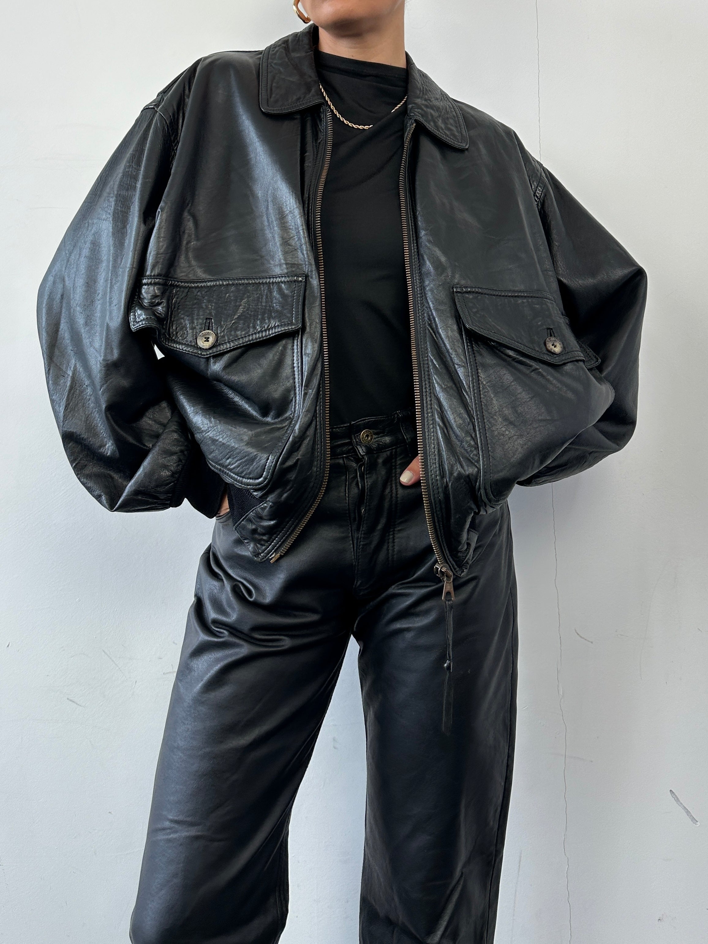 Vintage leather bomber jacket in size L featuring classic design and durable material, shown on a hanger.