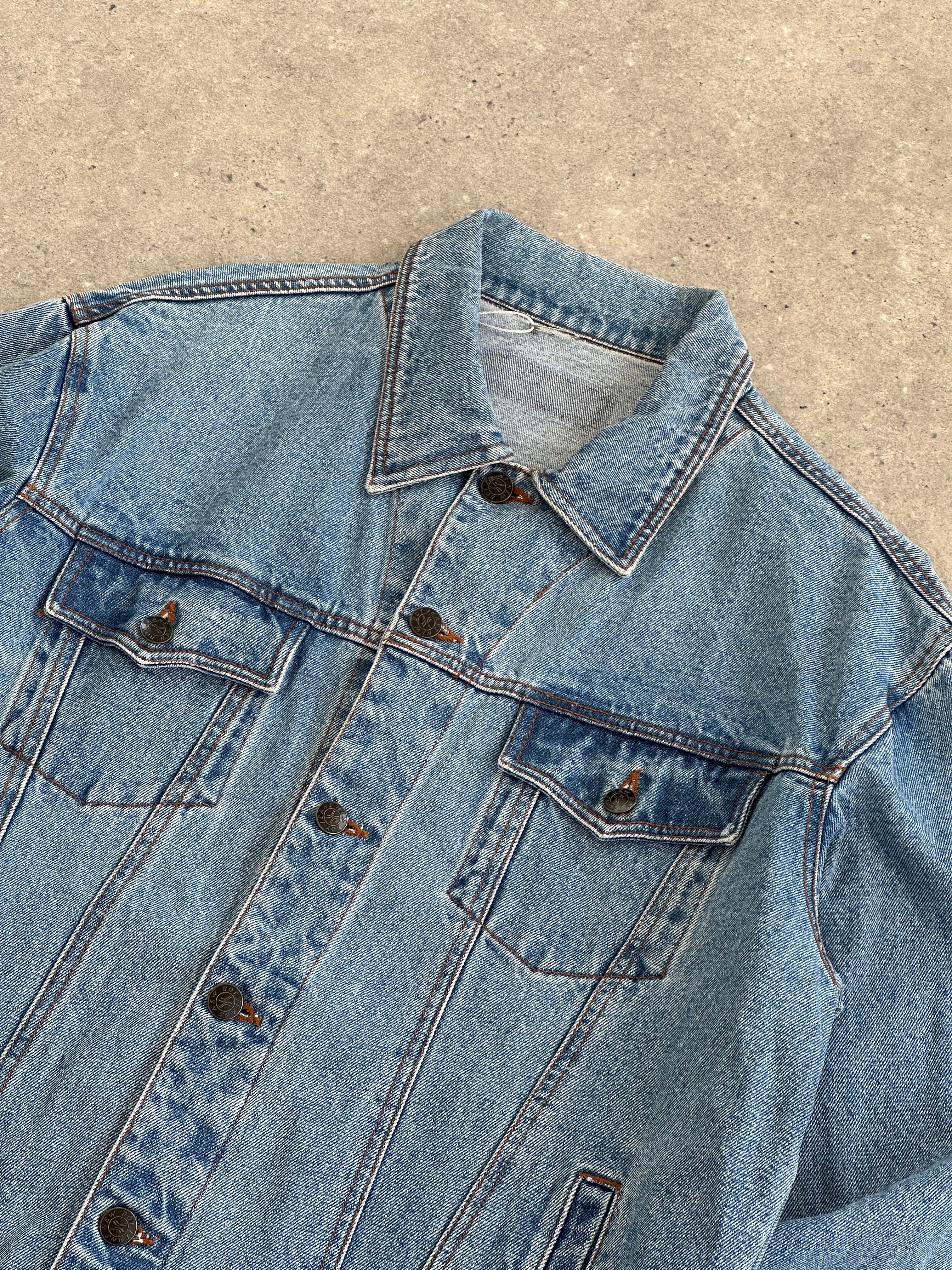 Vintage oversized pure cotton denim jacket with classic design, displayed on a hanger, showcasing its relaxed fit and vintage style.