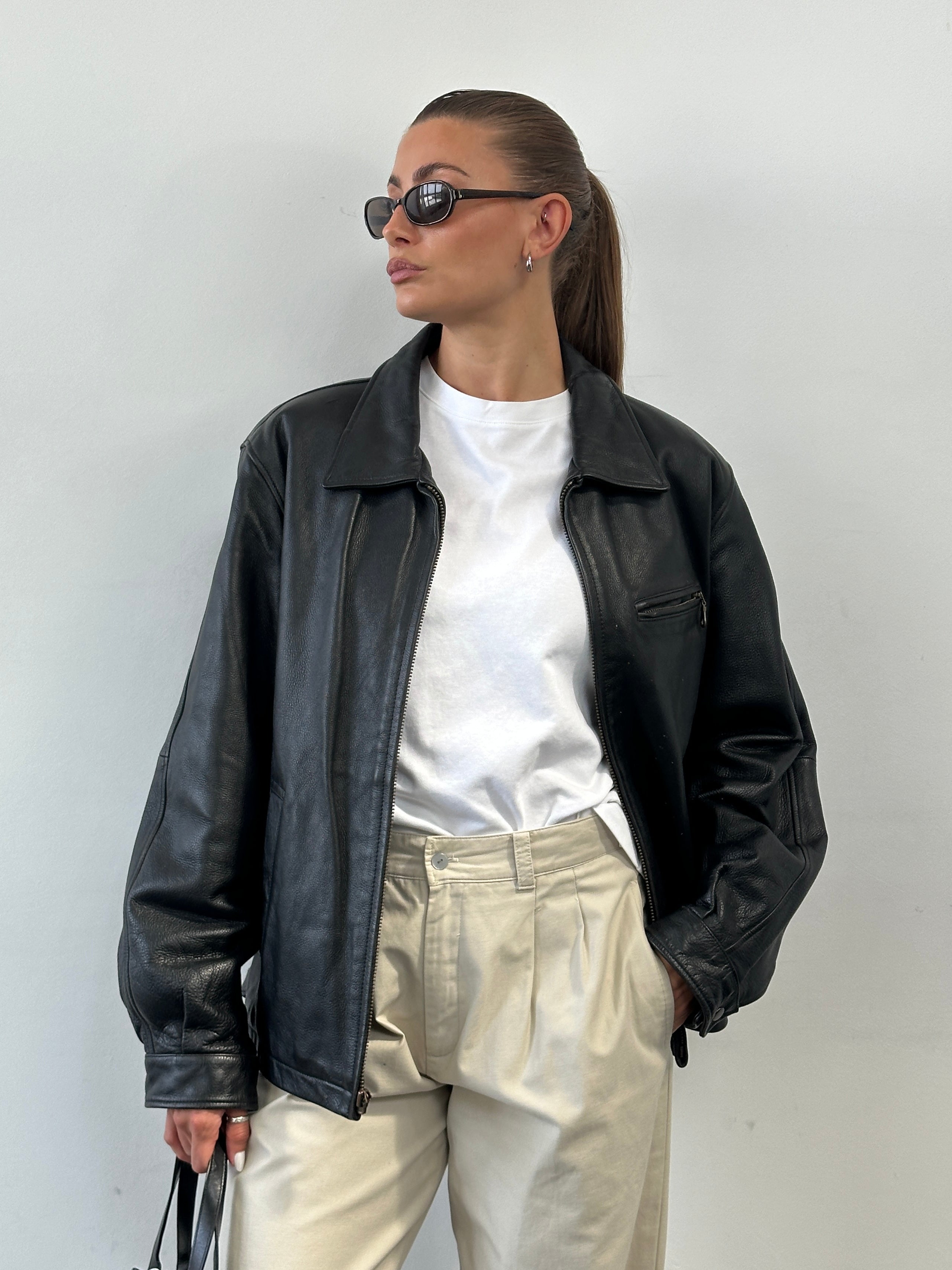 Vintage minimal leather jacket in size L, featuring a sleek design, classic collar, and smooth leather finish.