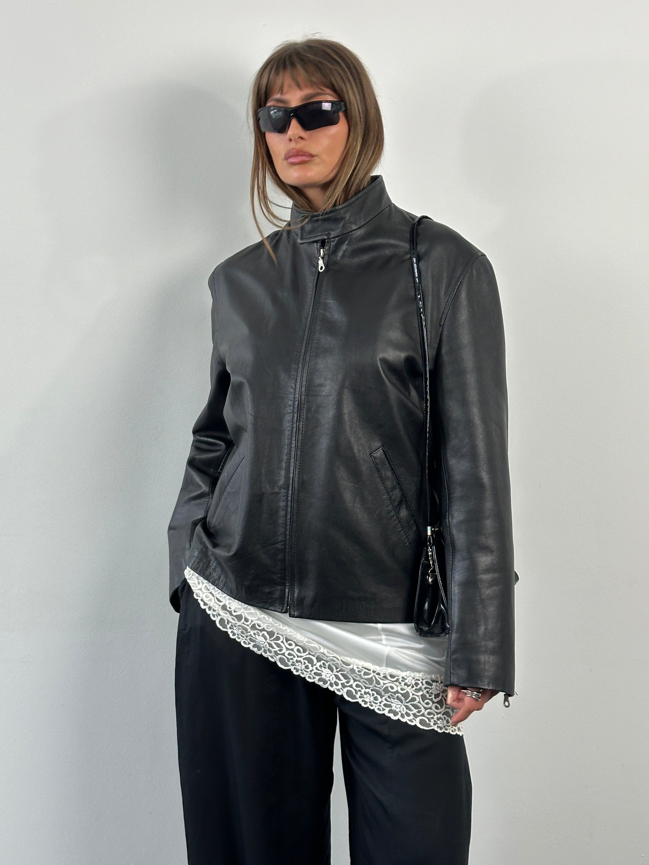 Vintage 2000s minimal high neck leather jacket in black, showing front view with sleek design and fitted silhouette.