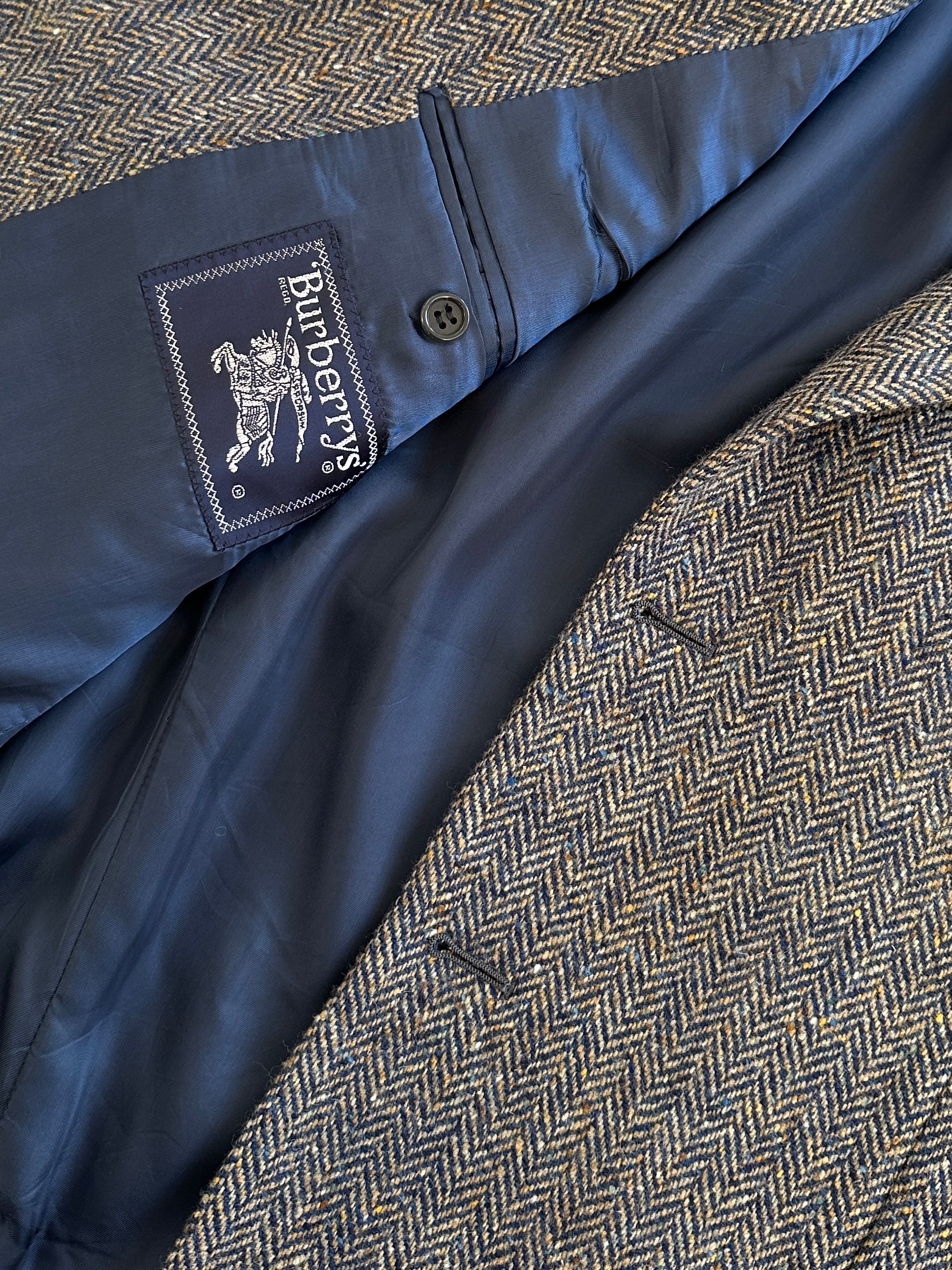 Burberry 1990s herringbone wool blazer, single-breasted, in size 42R/XL, featuring classic tailored design and herringbone pattern.