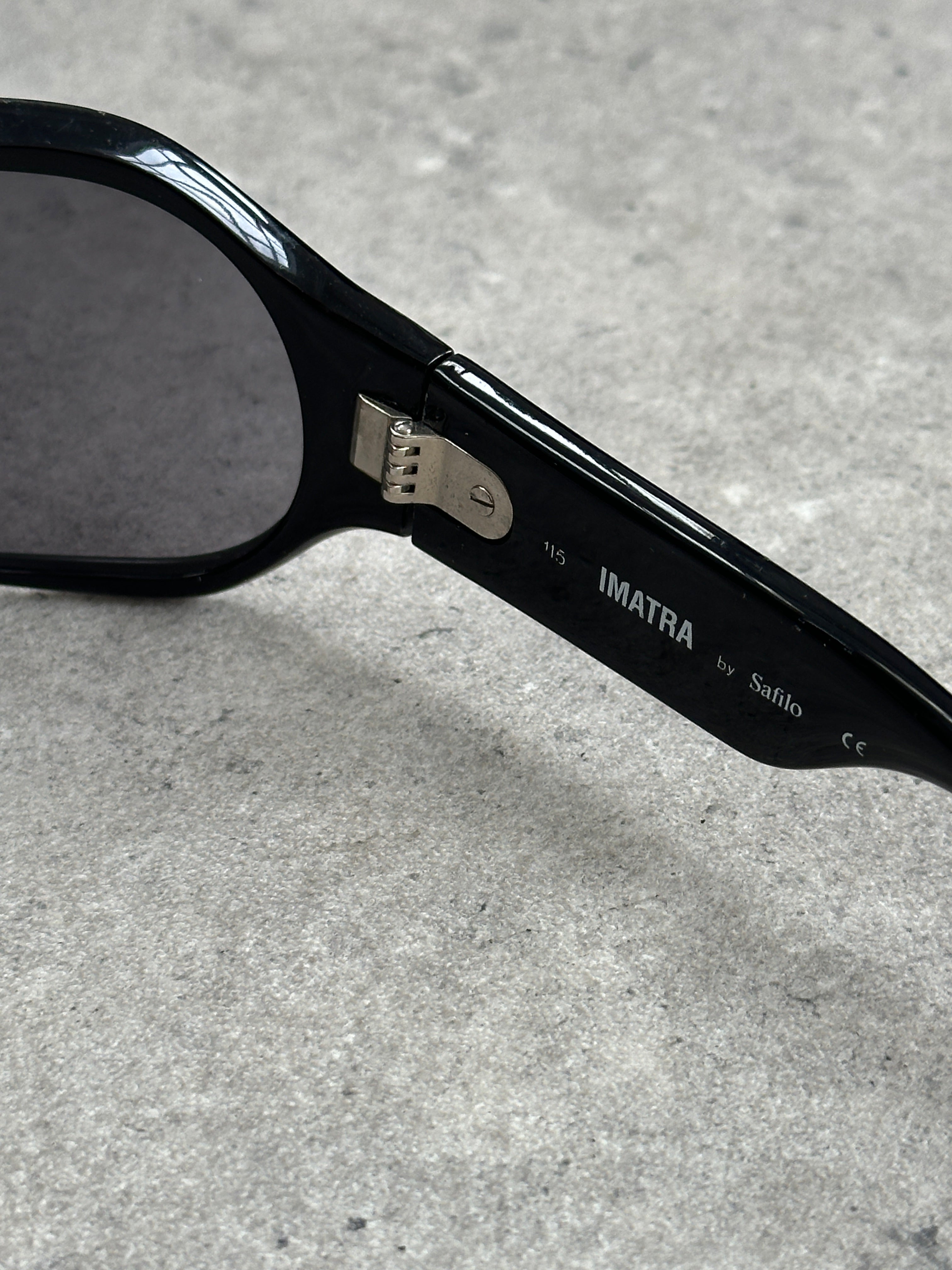 Vintage 2000s oversized shield sunglasses with dark tinted lenses and bold black frame, showcasing a retro fashion style.