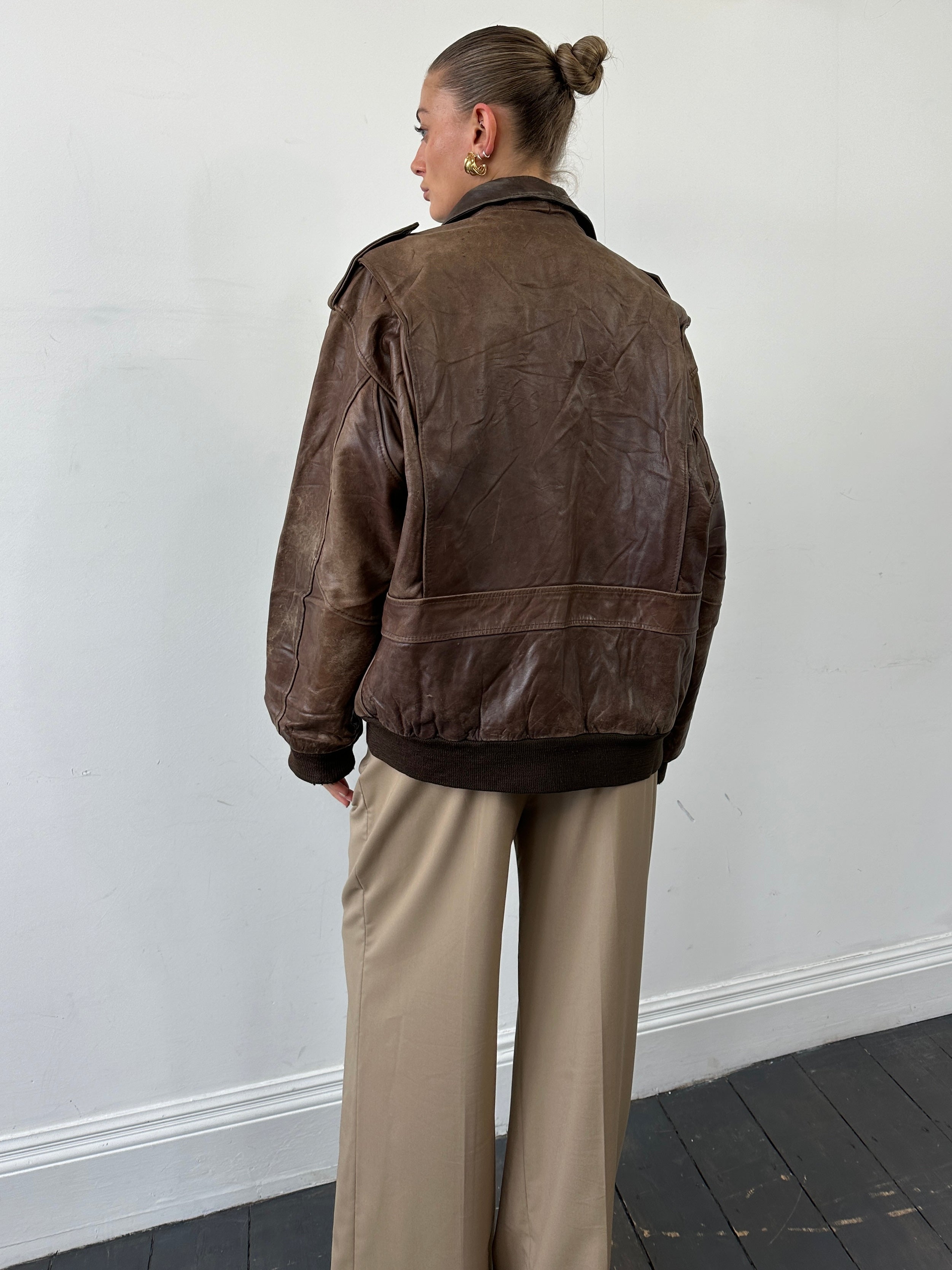 Vintage distressed leather bomber jacket in XL size with rugged style, featuring worn-in detailing and classic design.