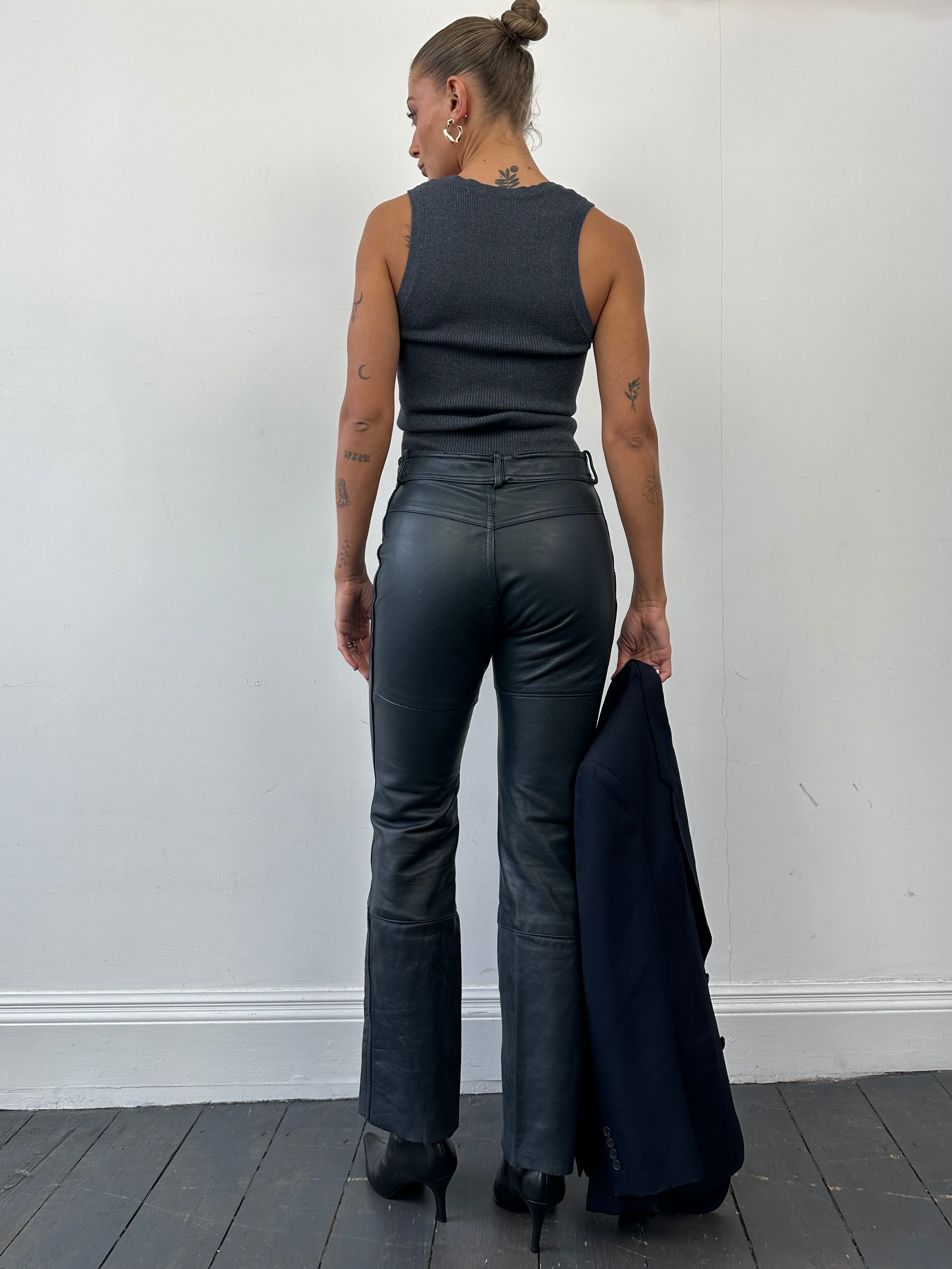 Vintage leather straight leg trousers in size W28, featuring a classic fit and authentic texture, shown on a neutral background.