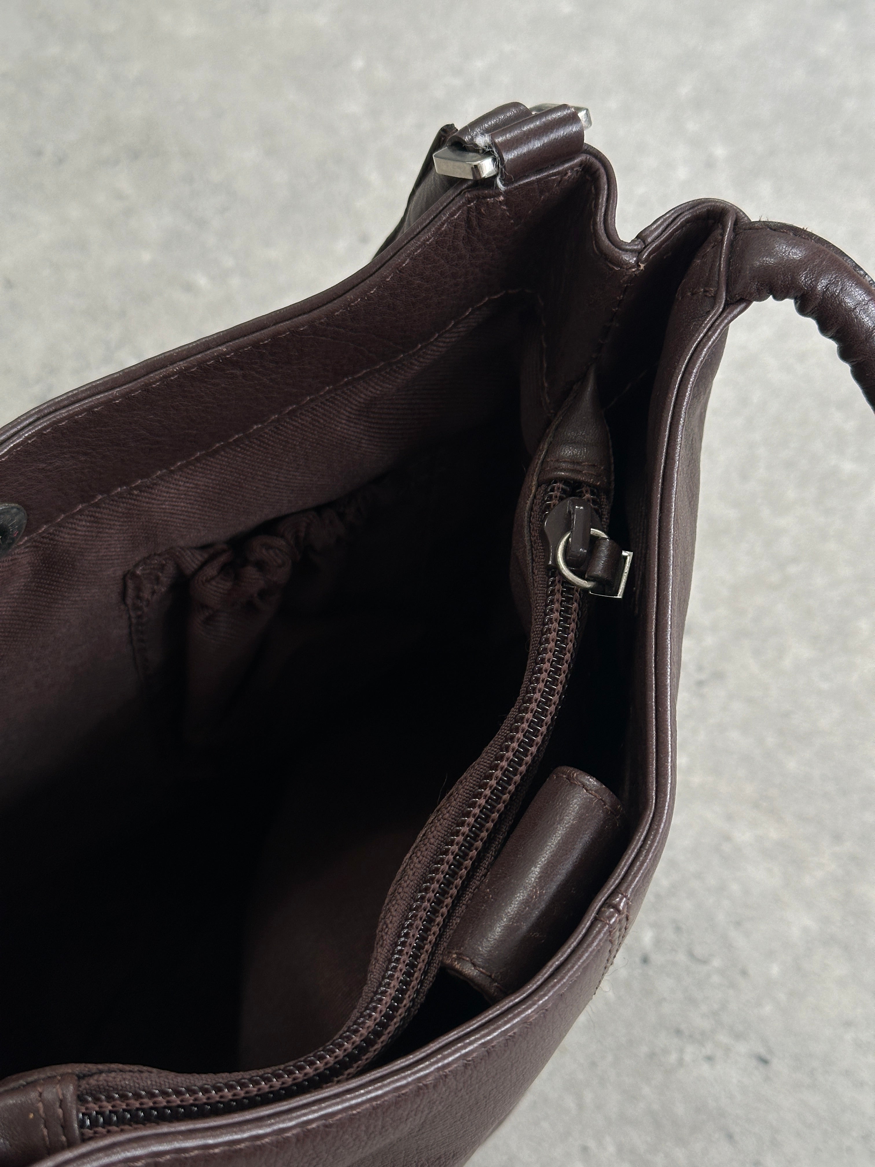 Vintage leather shoulder bag with adjustable strap, classic design, and worn-in finish, perfect for casual or stylish everyday use.