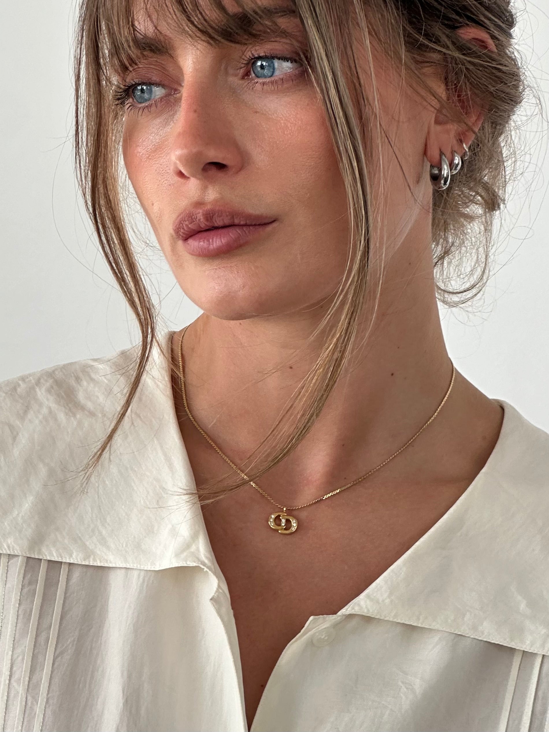 Christian Dior 16-inch gold plated rhinestone logo pendant necklace, featuring the iconic Dior branding and sparkling design.