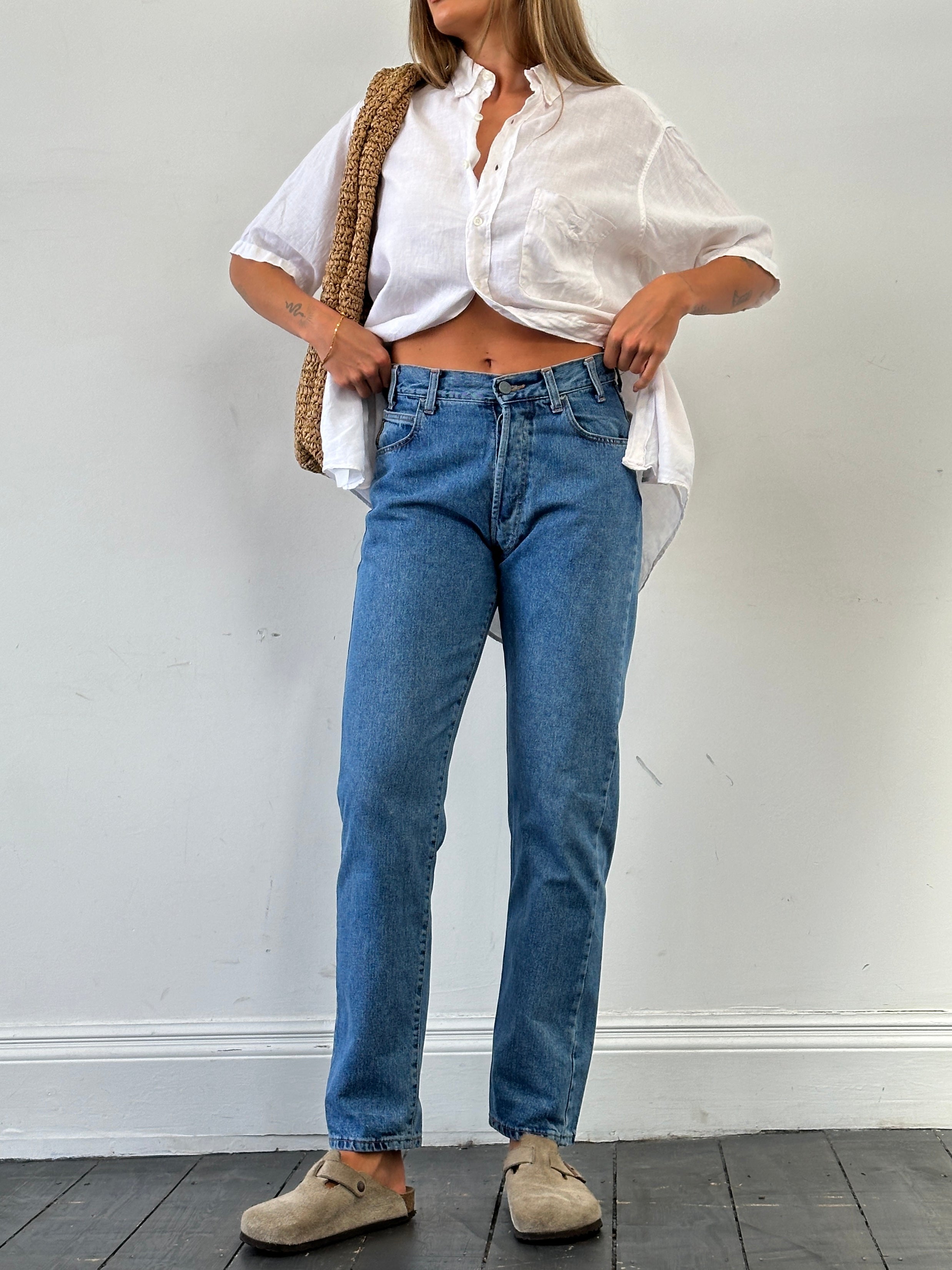 Armani Jeans mid wash tapered leg high waisted denim jeans, size W28, displayed on a hanger with visible stitching and fading details.