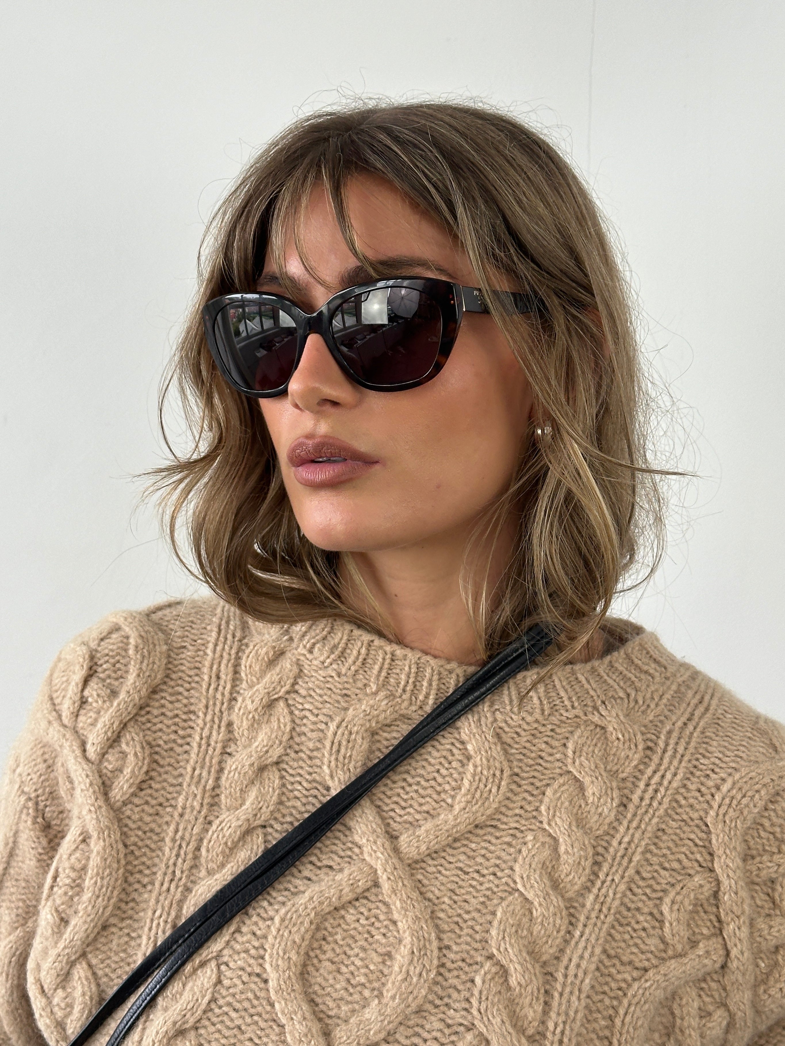 Prada tortoise shell round logo sunglasses with dark lenses and stylish frame, showcasing a classic and sophisticated design.