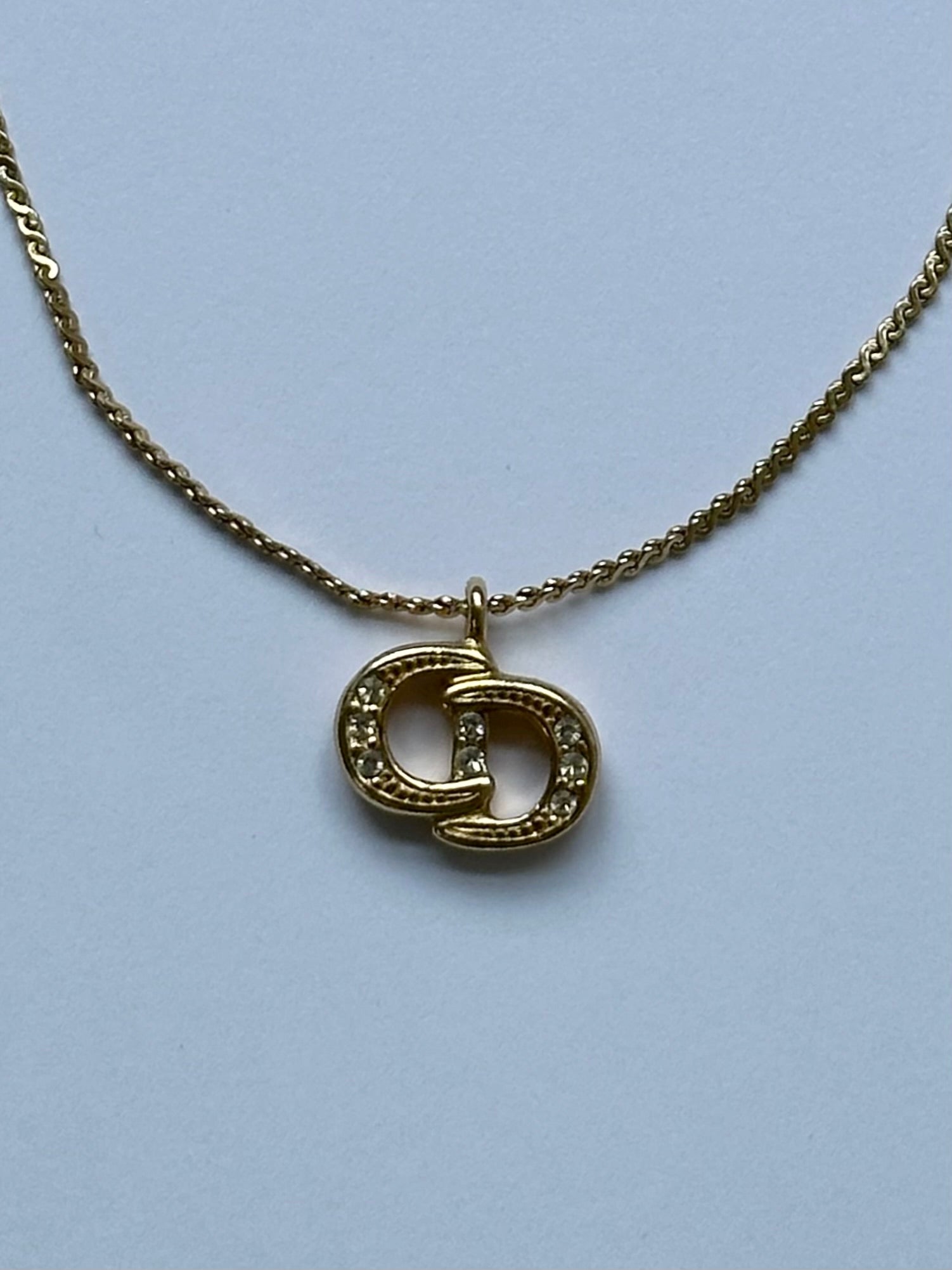 Christian Dior 16-inch gold-plated rhinestone logo pendant necklace with elegant design and sparkling detailing.