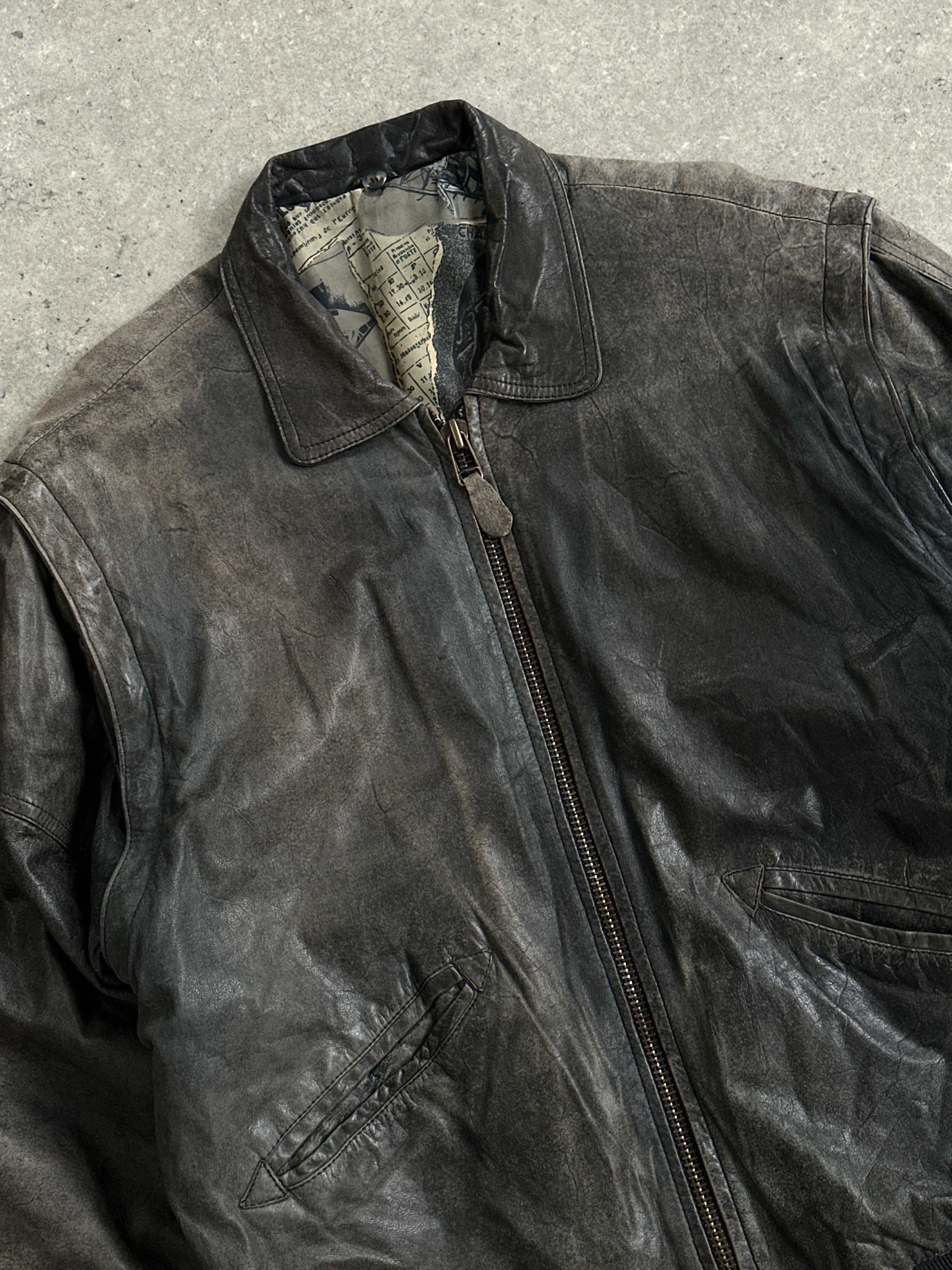 Vintage distressed leather bomber jacket in size L/XL, featuring a rugged, worn-in look with classic style and metal zipper details.
