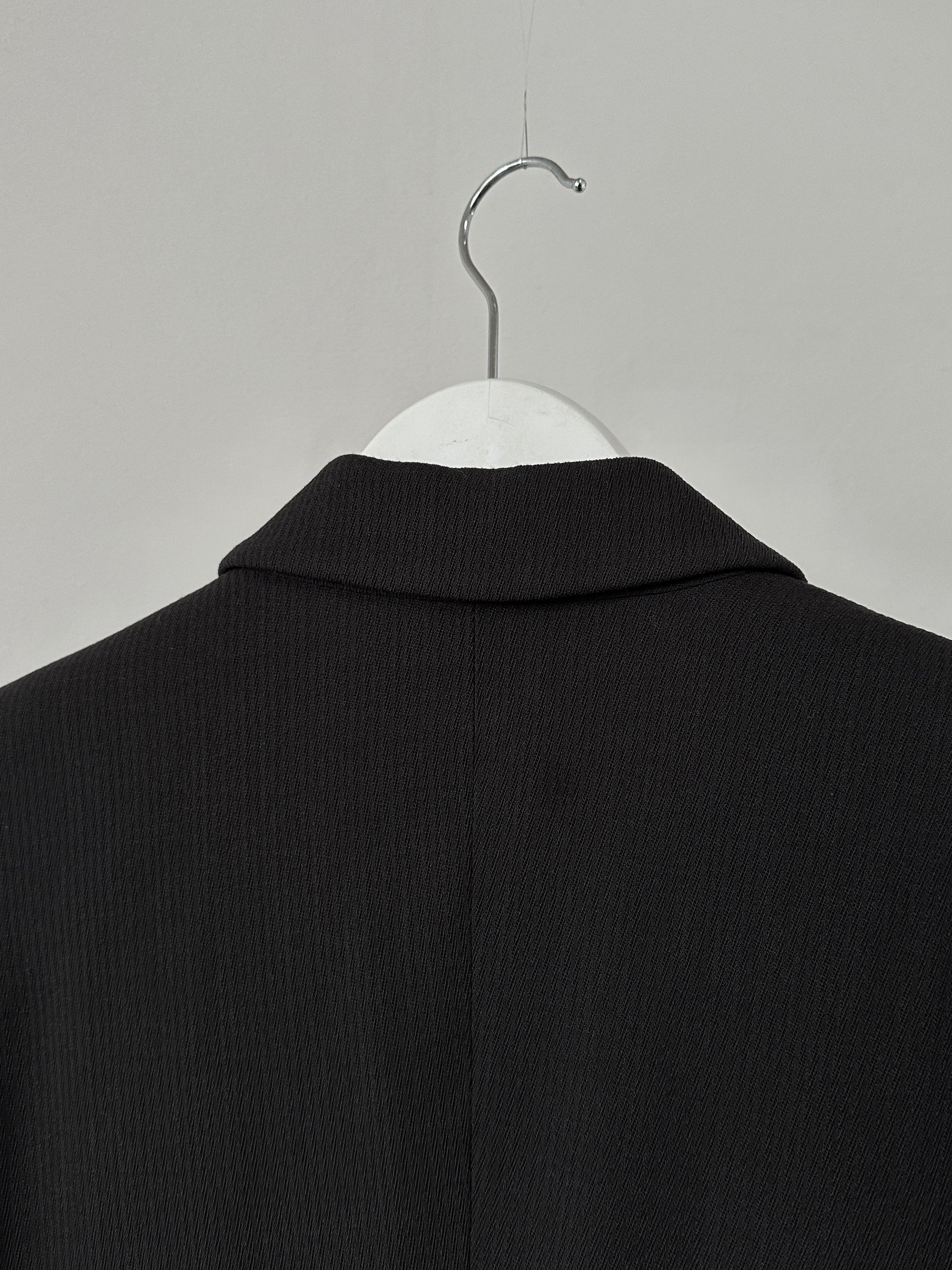 Armani Collezioni fitted single-button blazer in dark fabric, tailored style with notch lapel and structured shoulders.