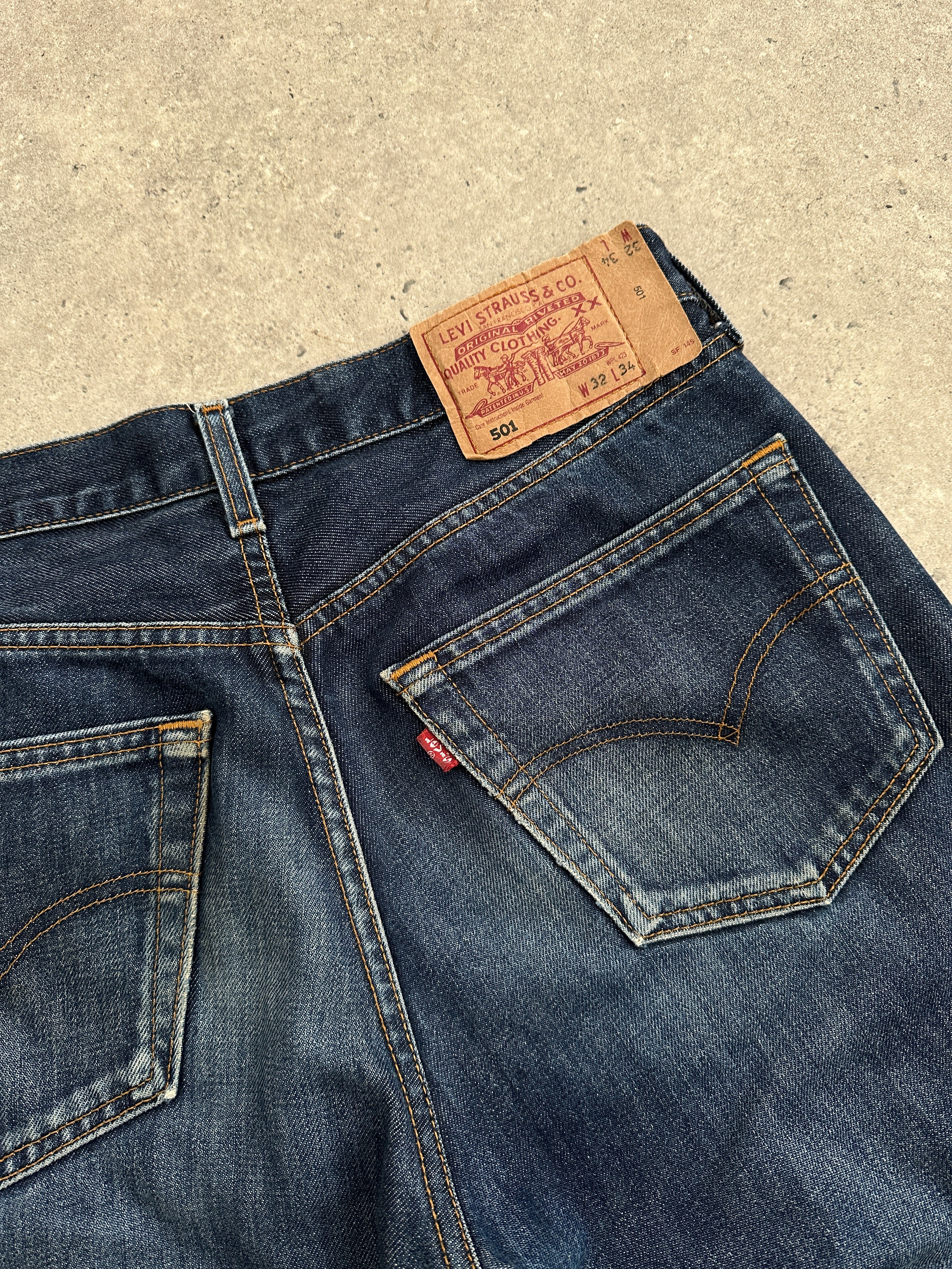 Levi’s 501 distressed straight leg denim jeans in W30, featuring a classic fit with ripped details and a light blue wash.