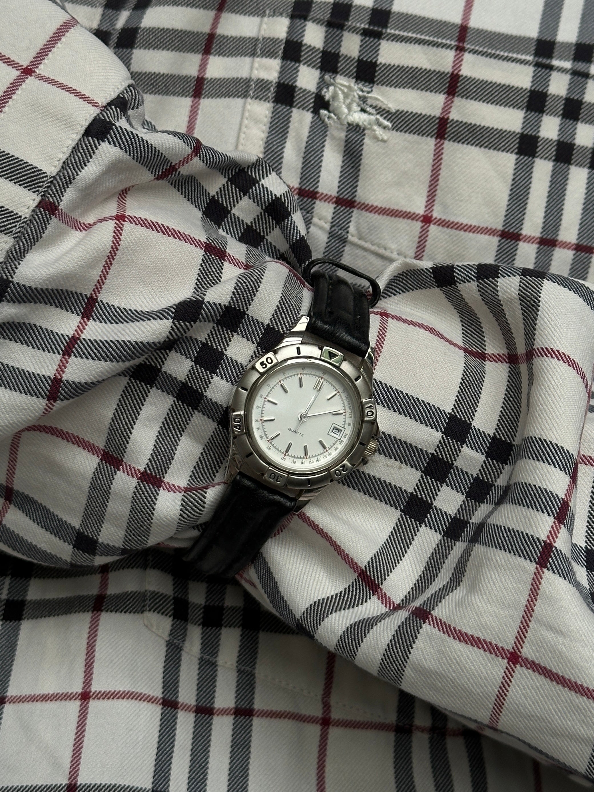 Vintage 1990s silver-tone quartz watch with round face and Japan movement, classic vintage timepiece.