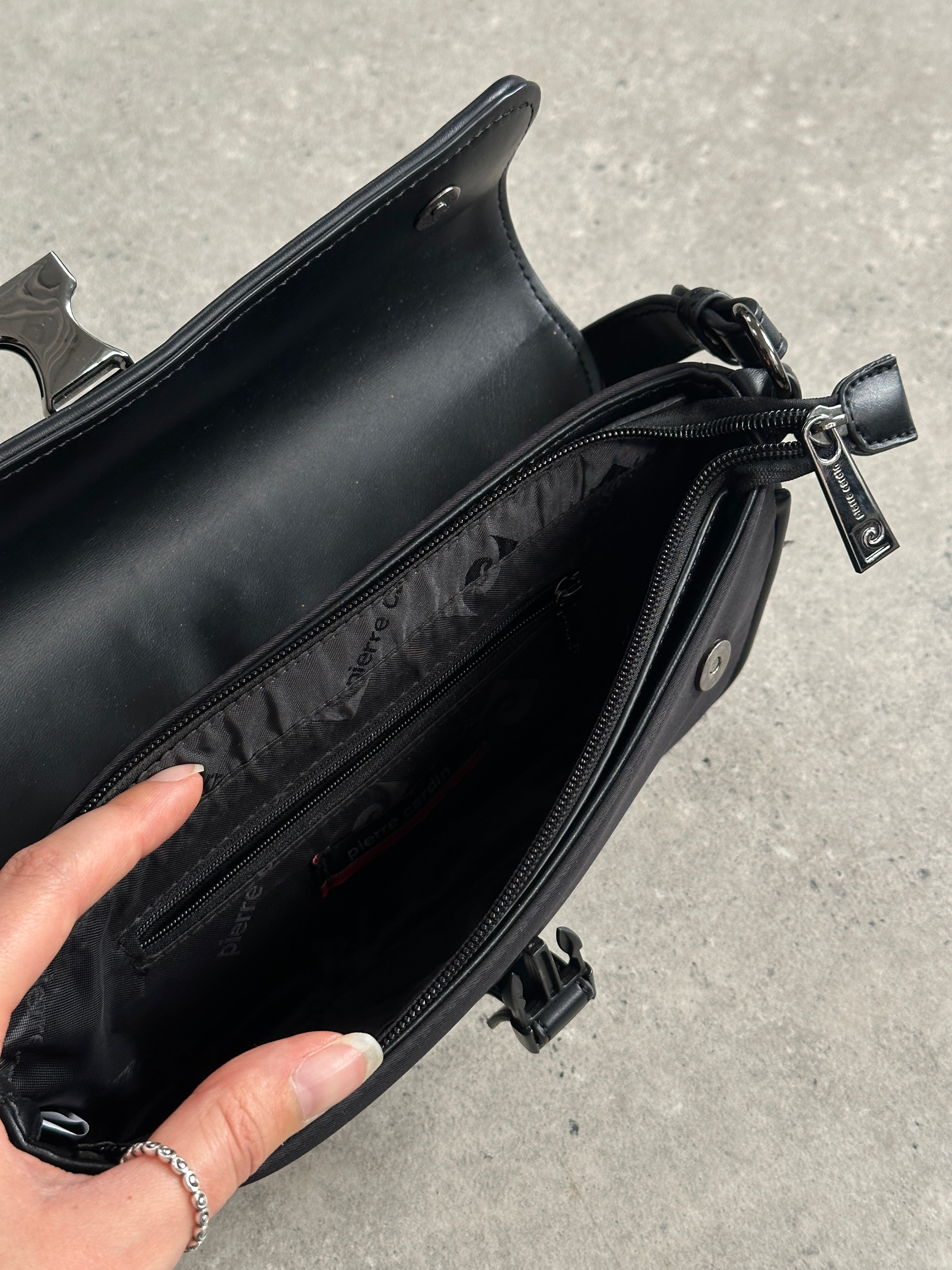 Pierre Cardin nylon shoulder bag with hardware, featuring a sleek design and adjustable strap for versatile carry.