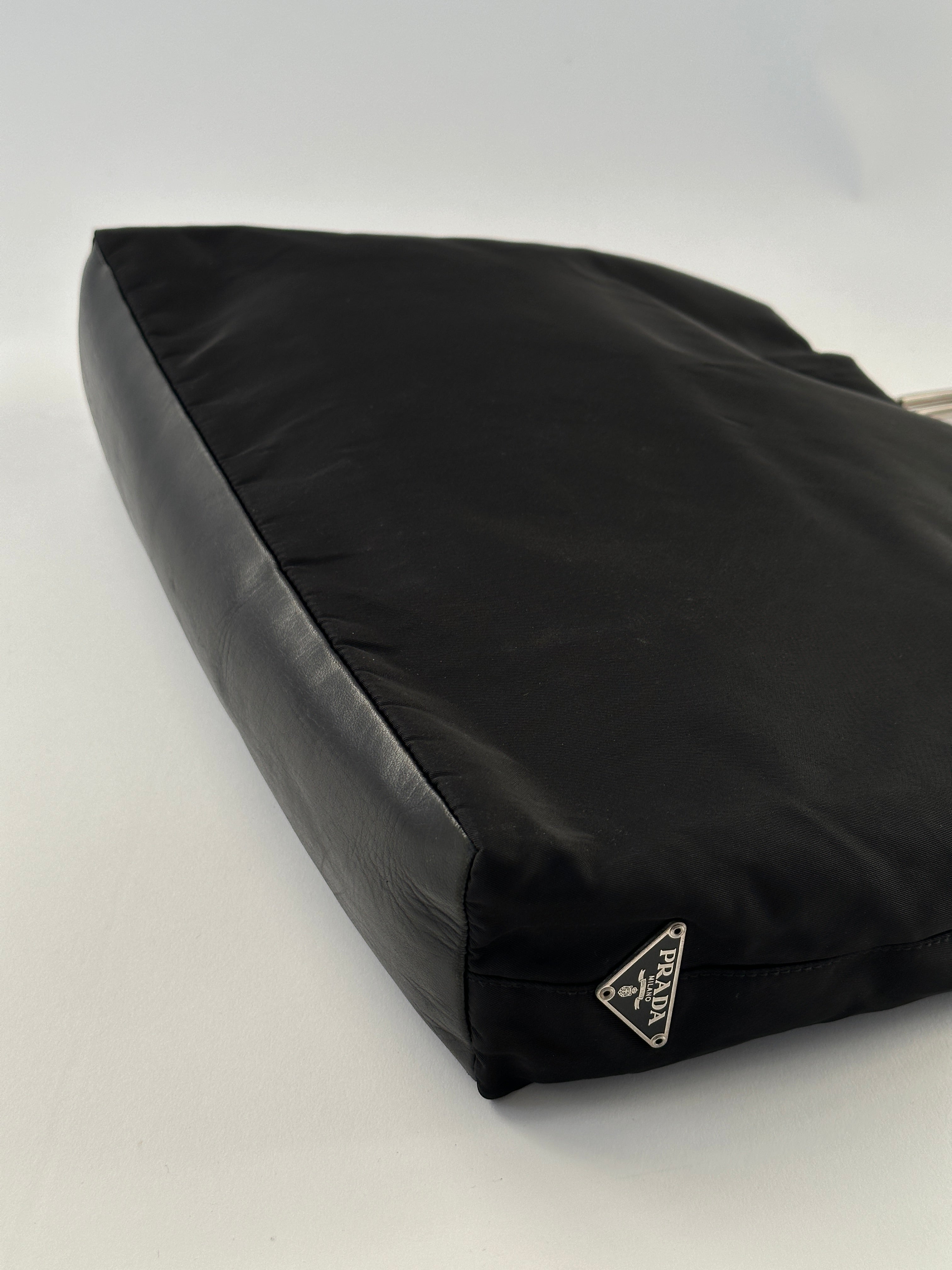 Prada nylon leather tote bag with sleek design, featuring sturdy handles and minimalist style for versatile carrying.