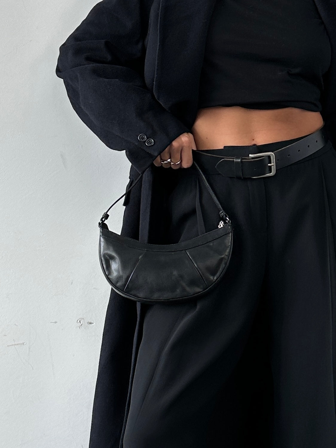 Vintage leather crescent shoulder bag with adjustable strap and stitched detailing, showcasing a classic vintage-style accessory.