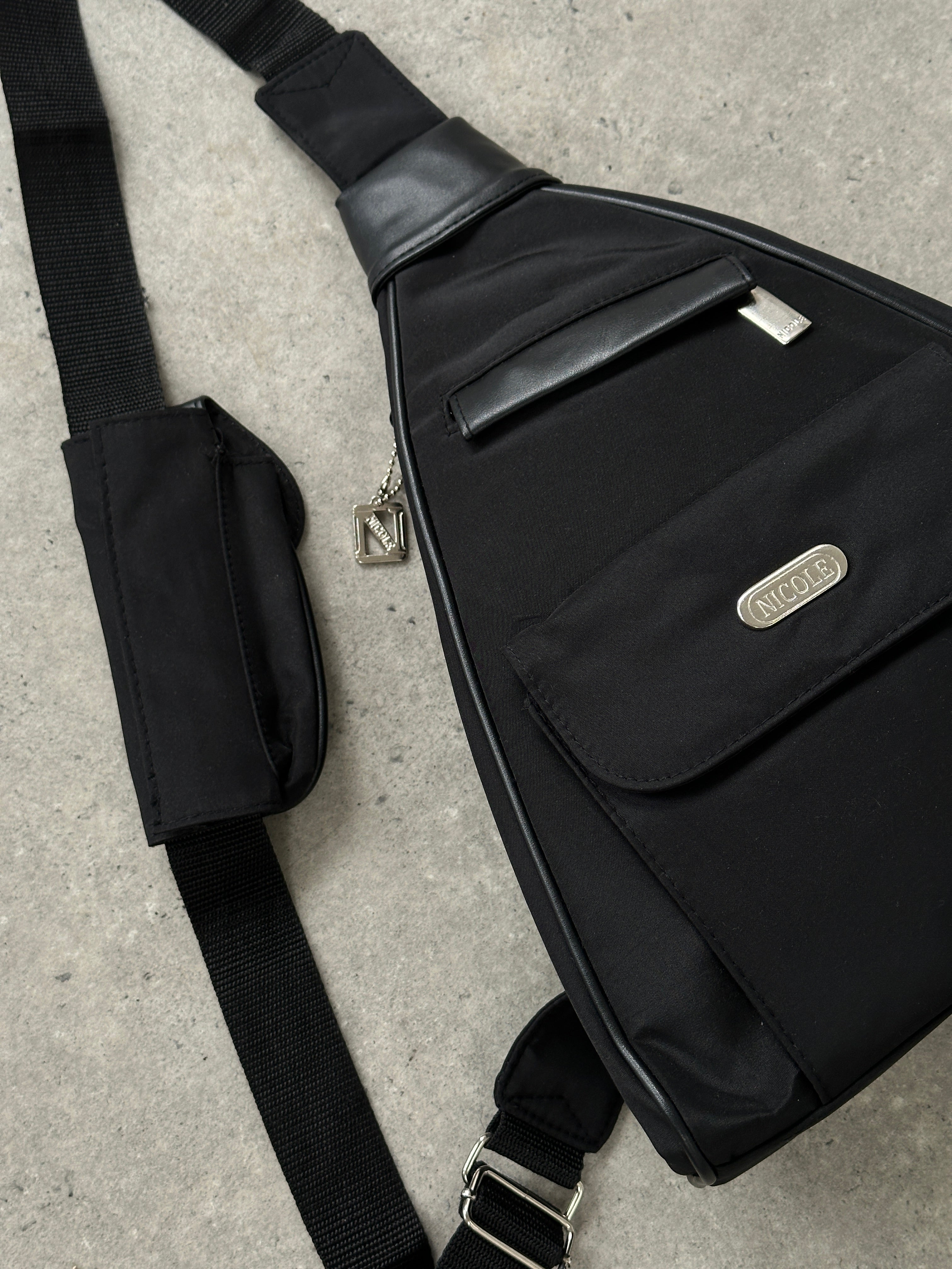 Vintage sling bag with adjustable strap and classic design, featuring brown leather accents and spacious interior.
