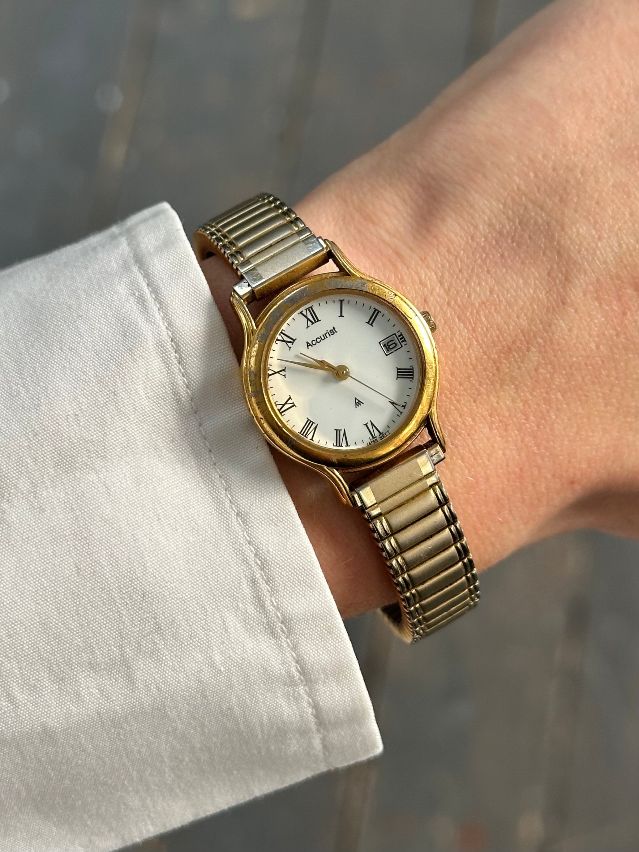 Accurist 1990s gold-tone quartz watch with a round face and metal bracelet, showcasing a vintage style timepiece.
