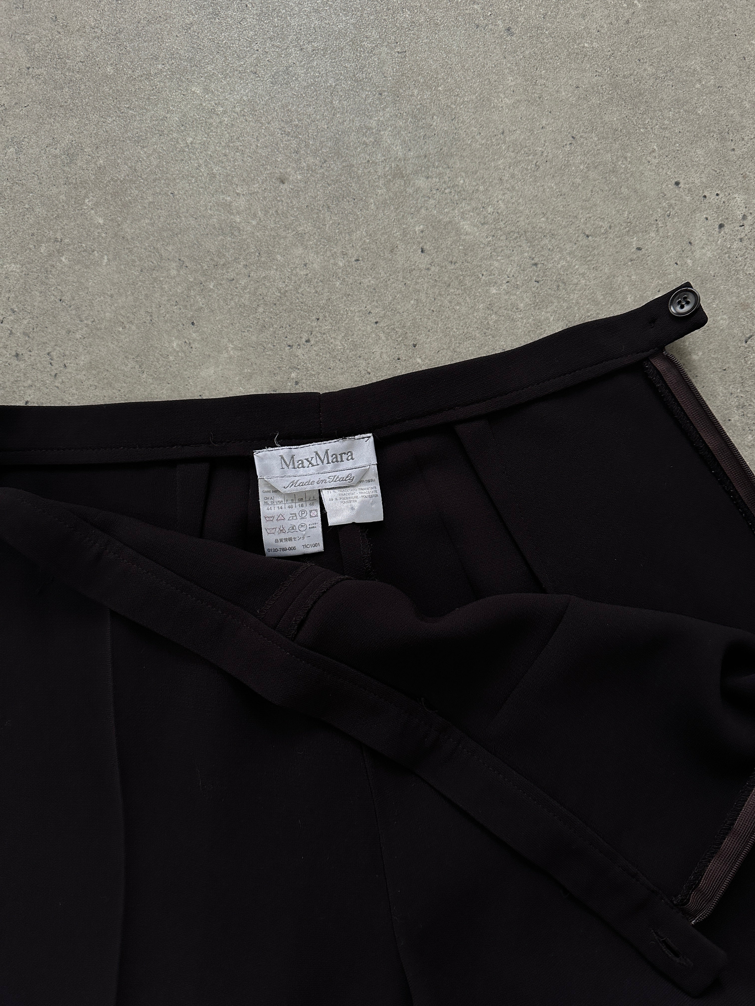 Max Mara minimal wide leg trousers in size W32, shown on a model, featuring a sleek, tailored design with a high waist and wide legs.