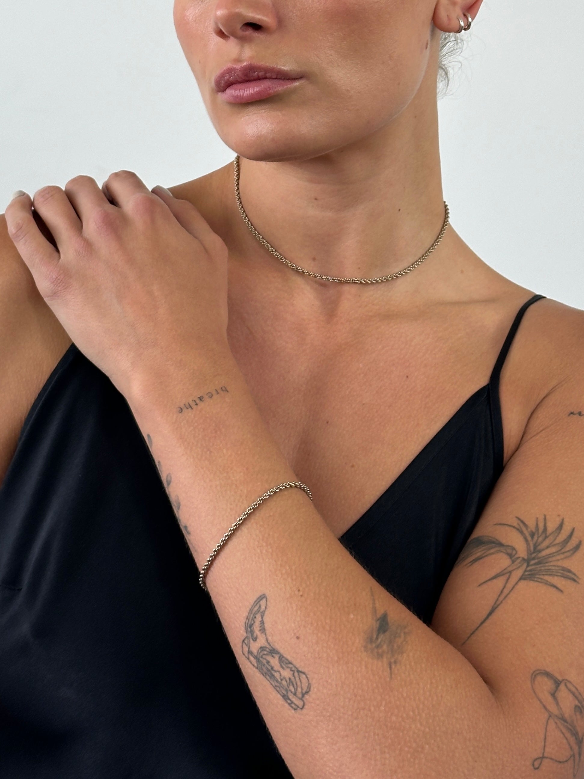 Pierre Cardin gold plated necklace and bracelet chain set with sleek, matching jewelry pieces on a neutral background.