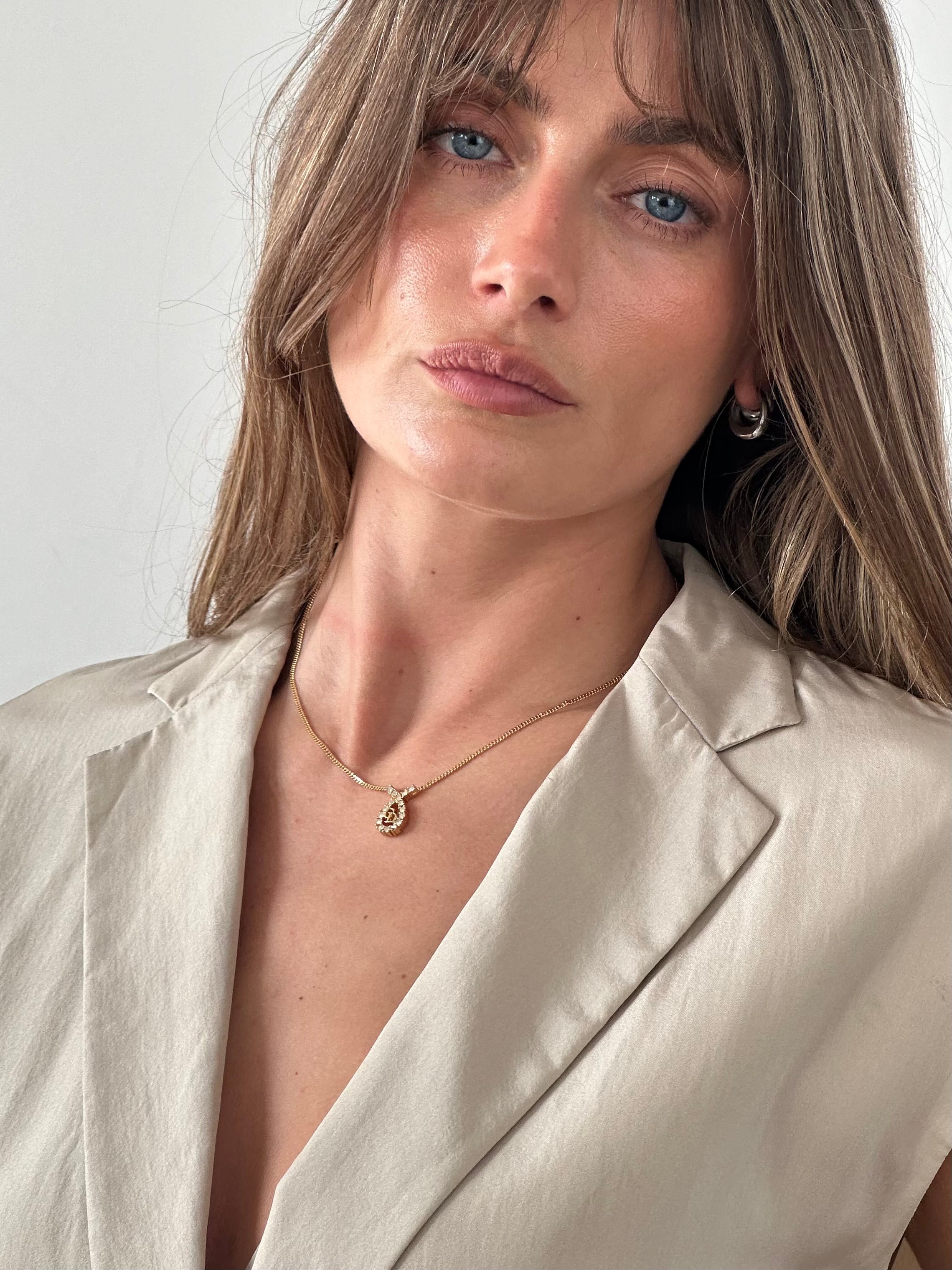 Christian Dior 16-inch gold plated rhinestone drop logo pendant necklace with elegant design and sparkling embellishments.