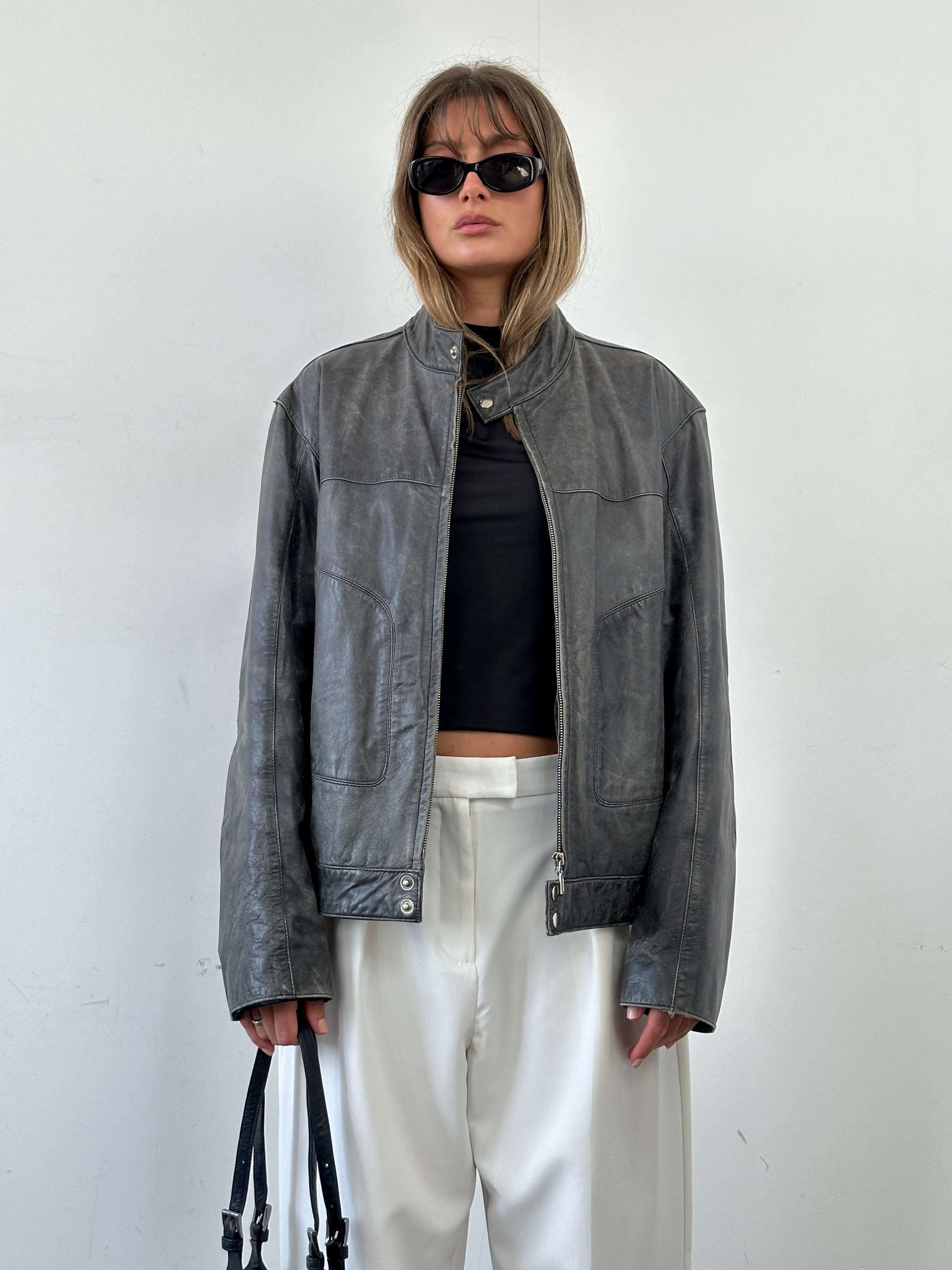 Vintage distressed leather moto jacket in size L/XL, featuring a rugged design and classic biker style.