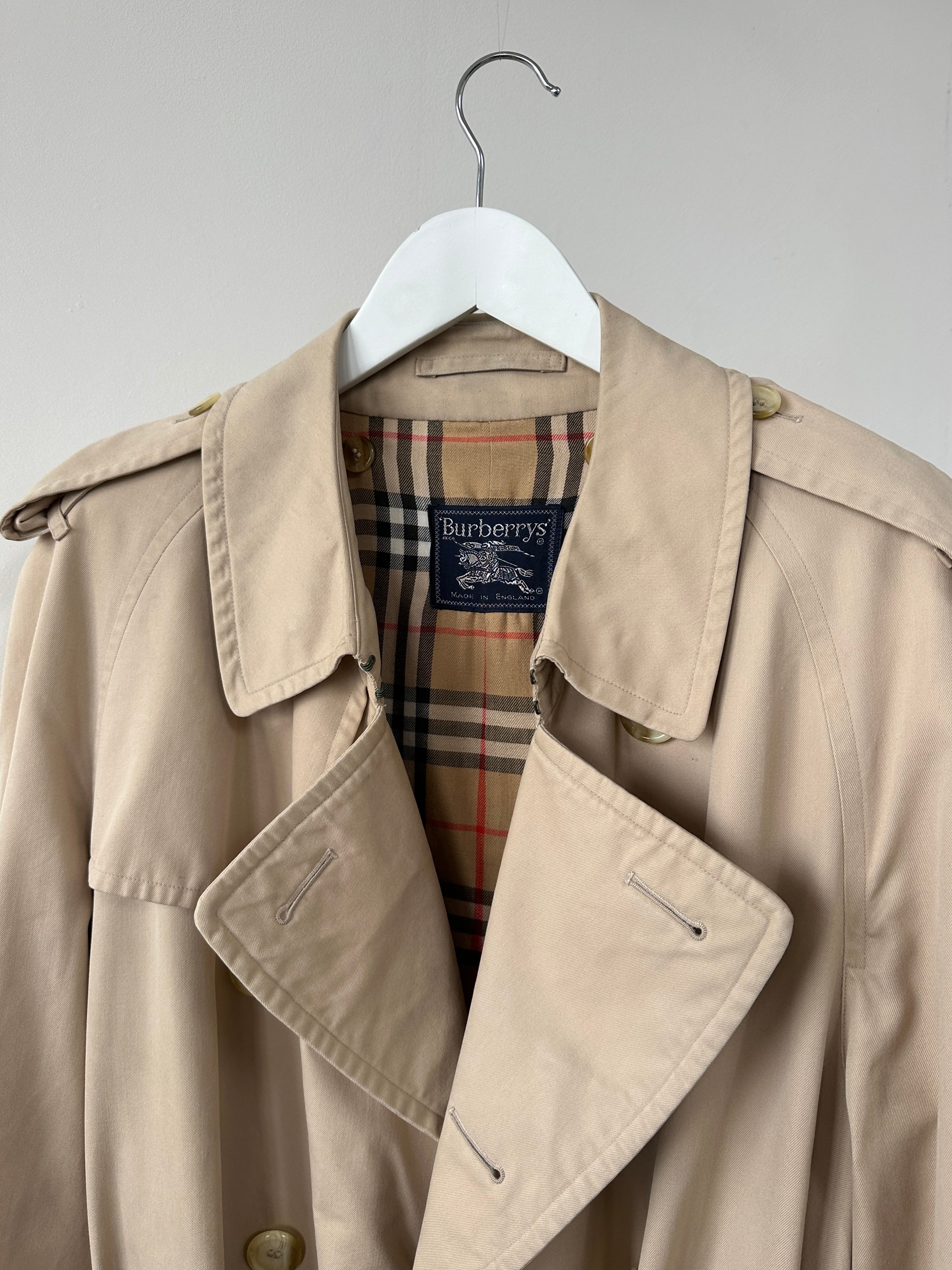 Burberry double-breasted trench coat in XL size, beige color, with classic collar and button details, stylish outerwear for women.