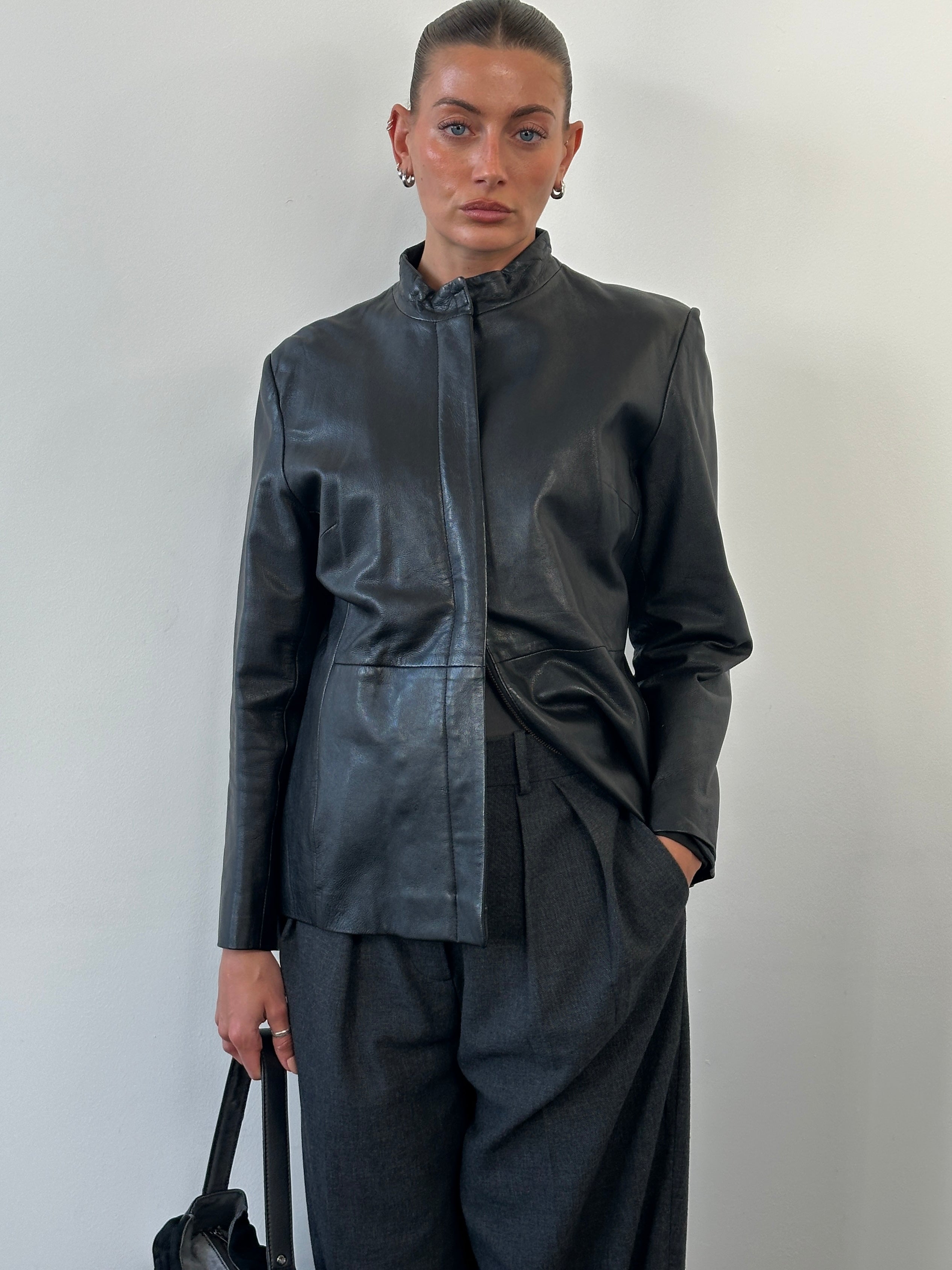 Vintage 1990s minimal round neck leather jacket in size M, featuring sleek design and classic black leather.