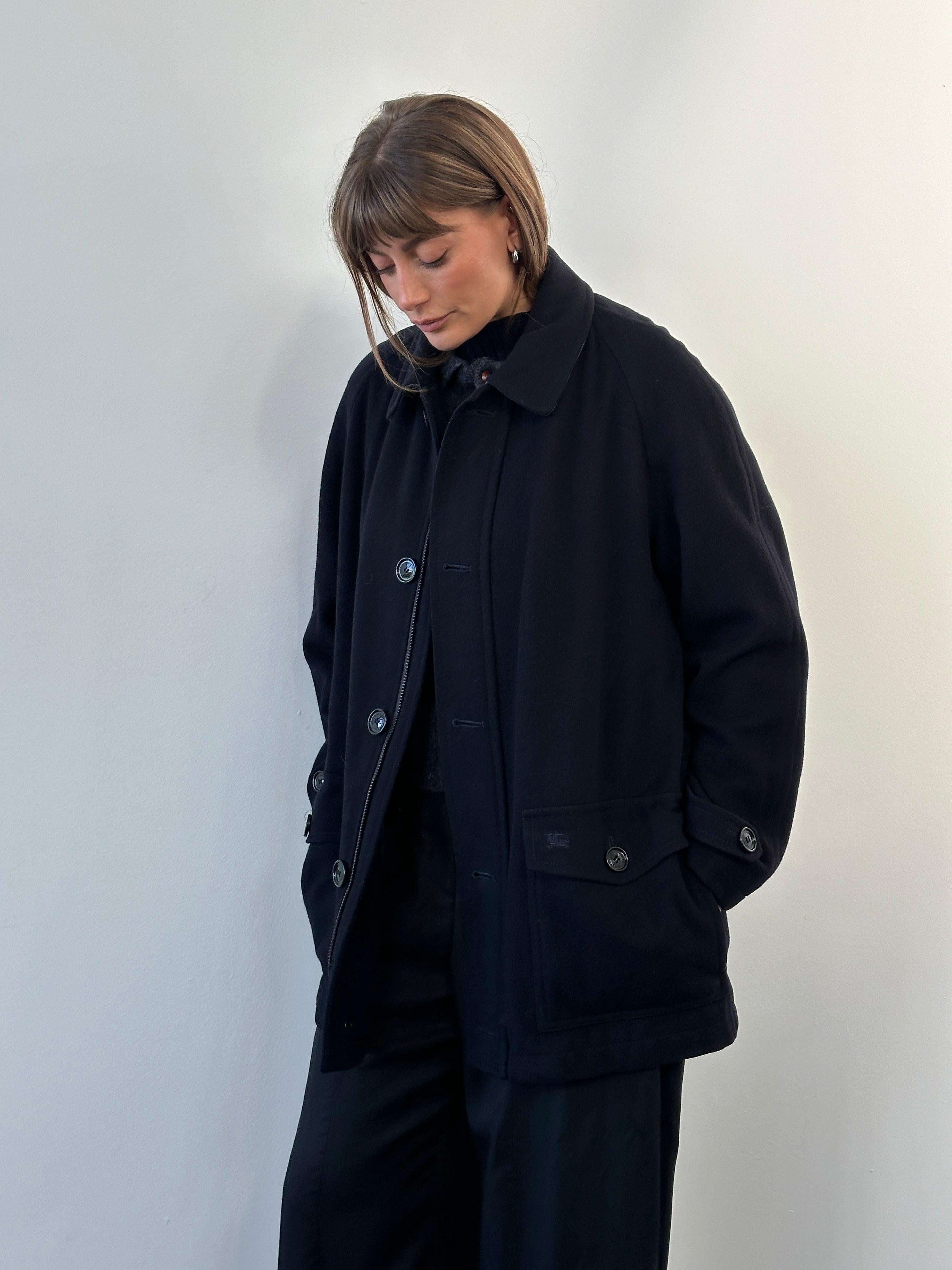 Burberry London 1990s wool single-breasted logo coat in size L/XL, shown hanging with classic check lining visible.