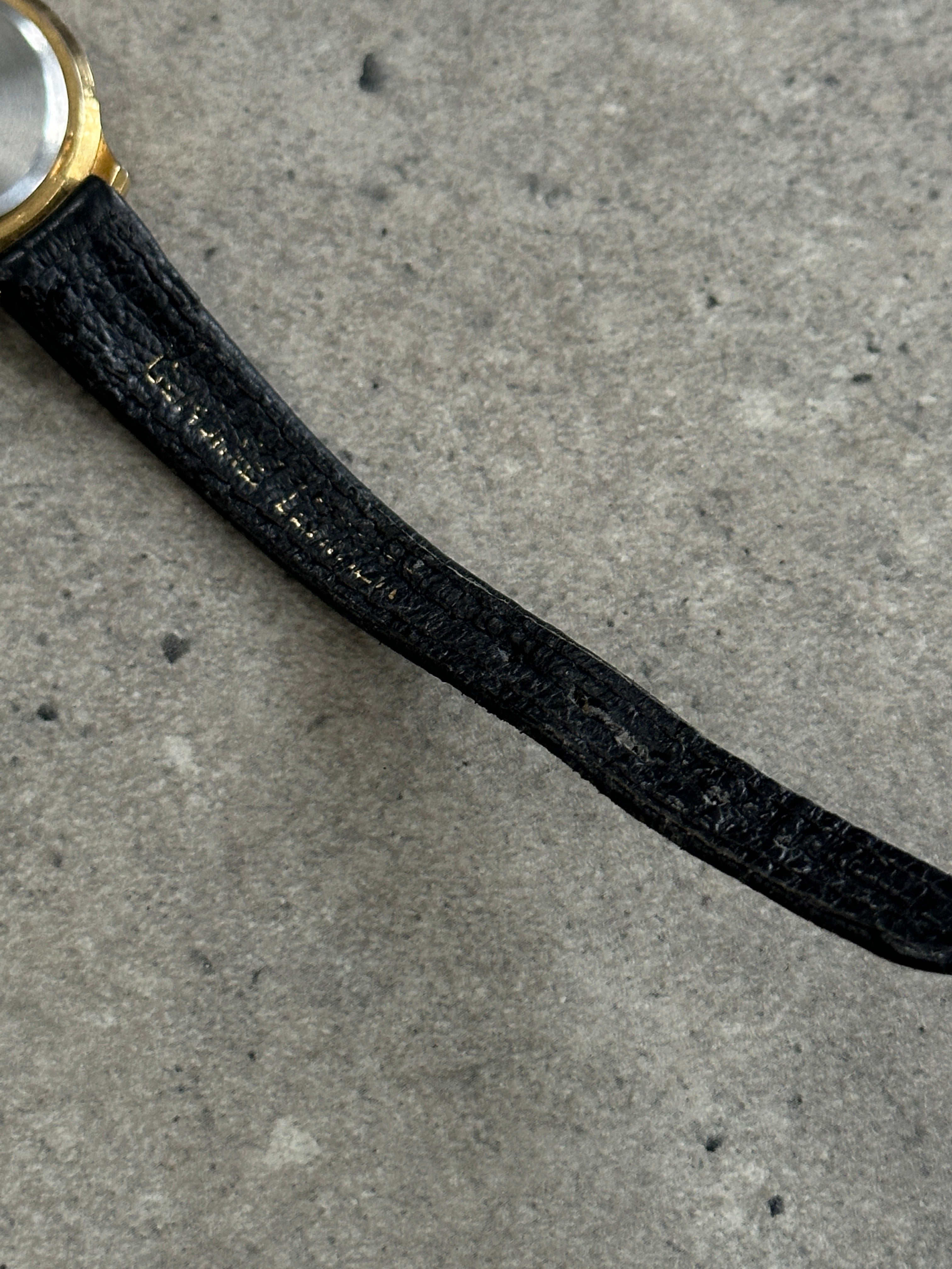 Vintage 1990s gold-tone round quartz watch with a classic design and metal bracelet, showcasing a vintage timepiece style.