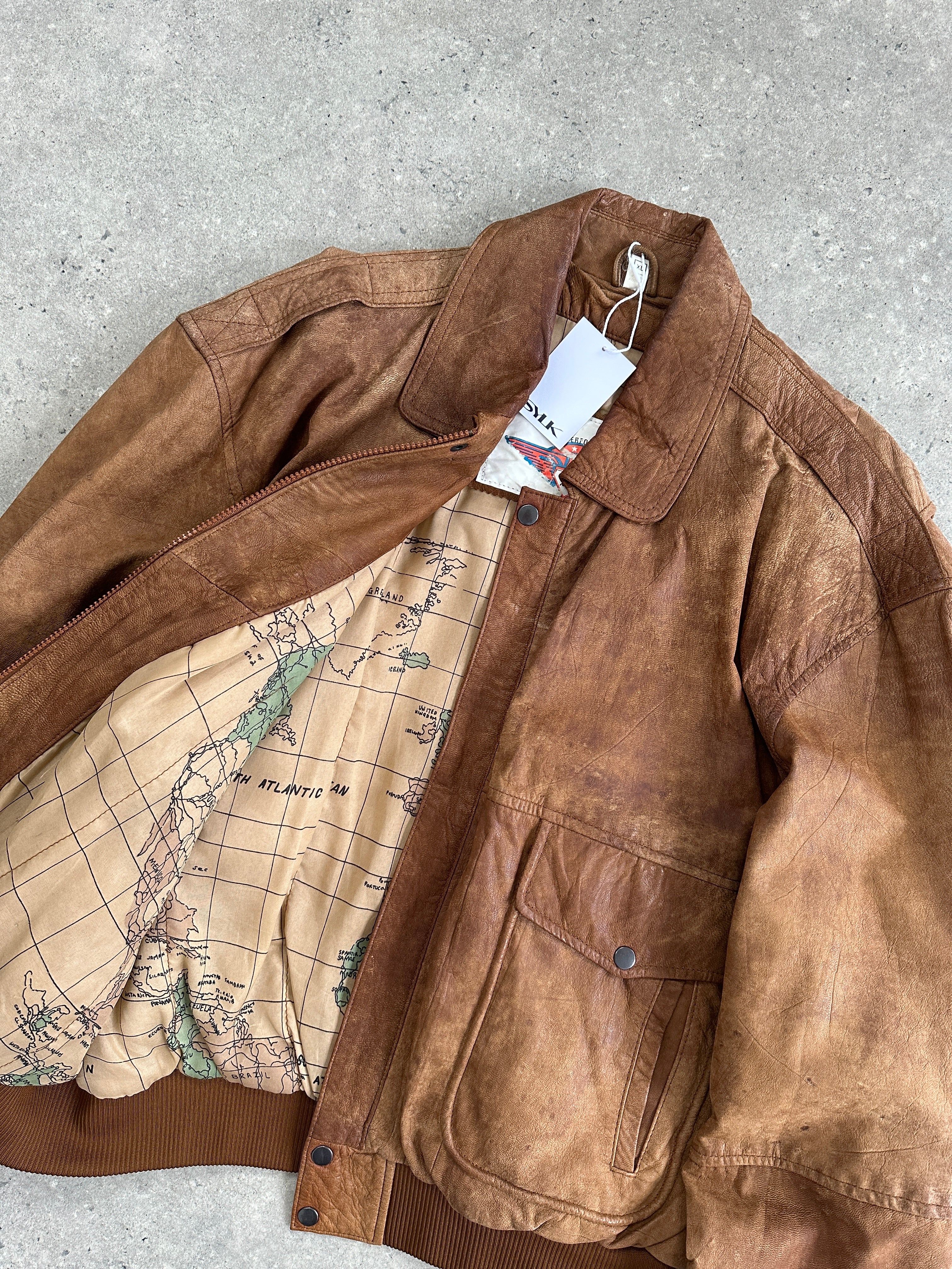 Vintage aged leather bomber jacket in XL size, featuring a classic design with a worn, rugged leather finish and ribbed cuffs.
