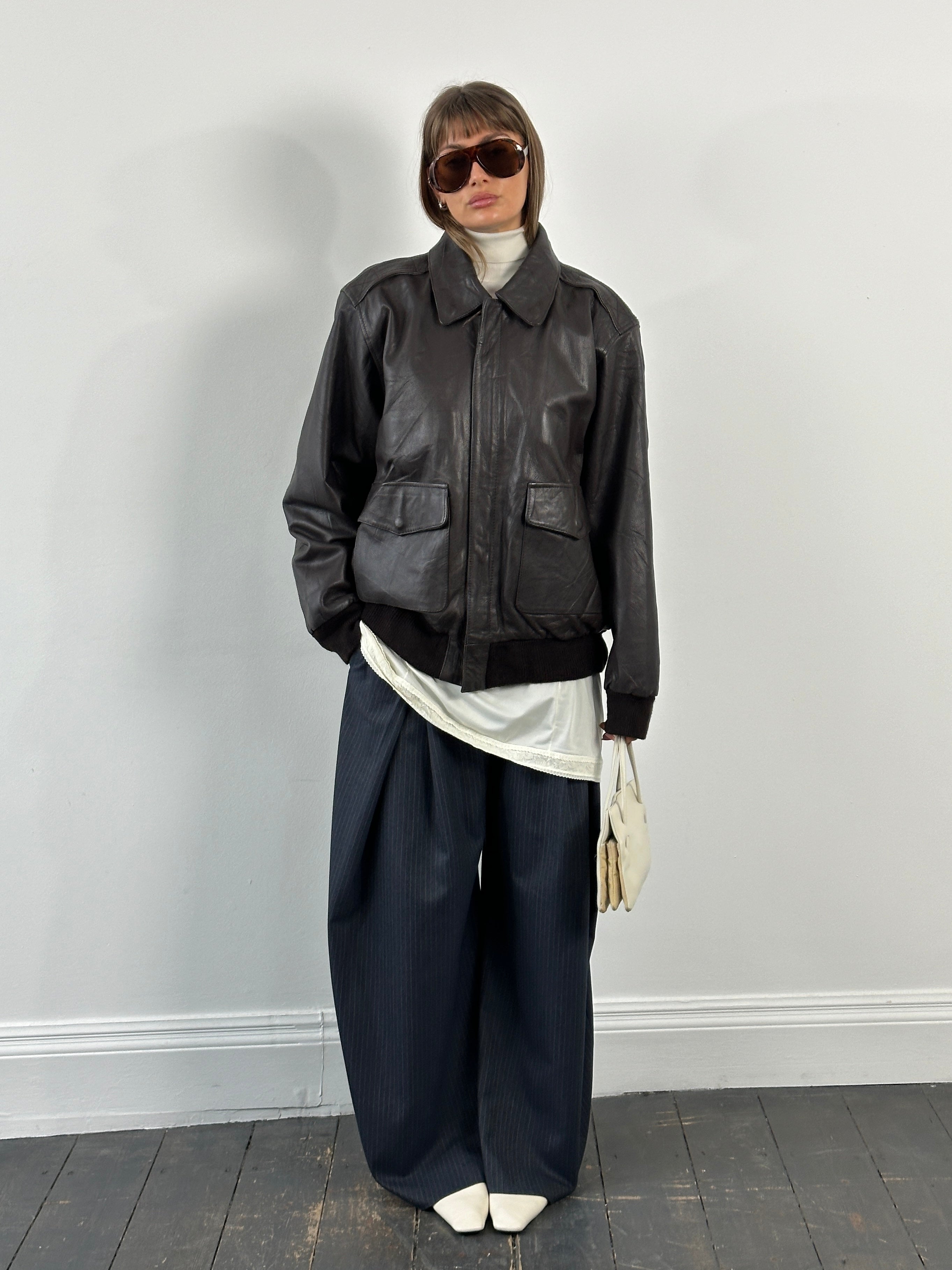 Vintage 1990s leather bomber jacket with concealed placket in XL size, featuring classic design and authentic leather material.