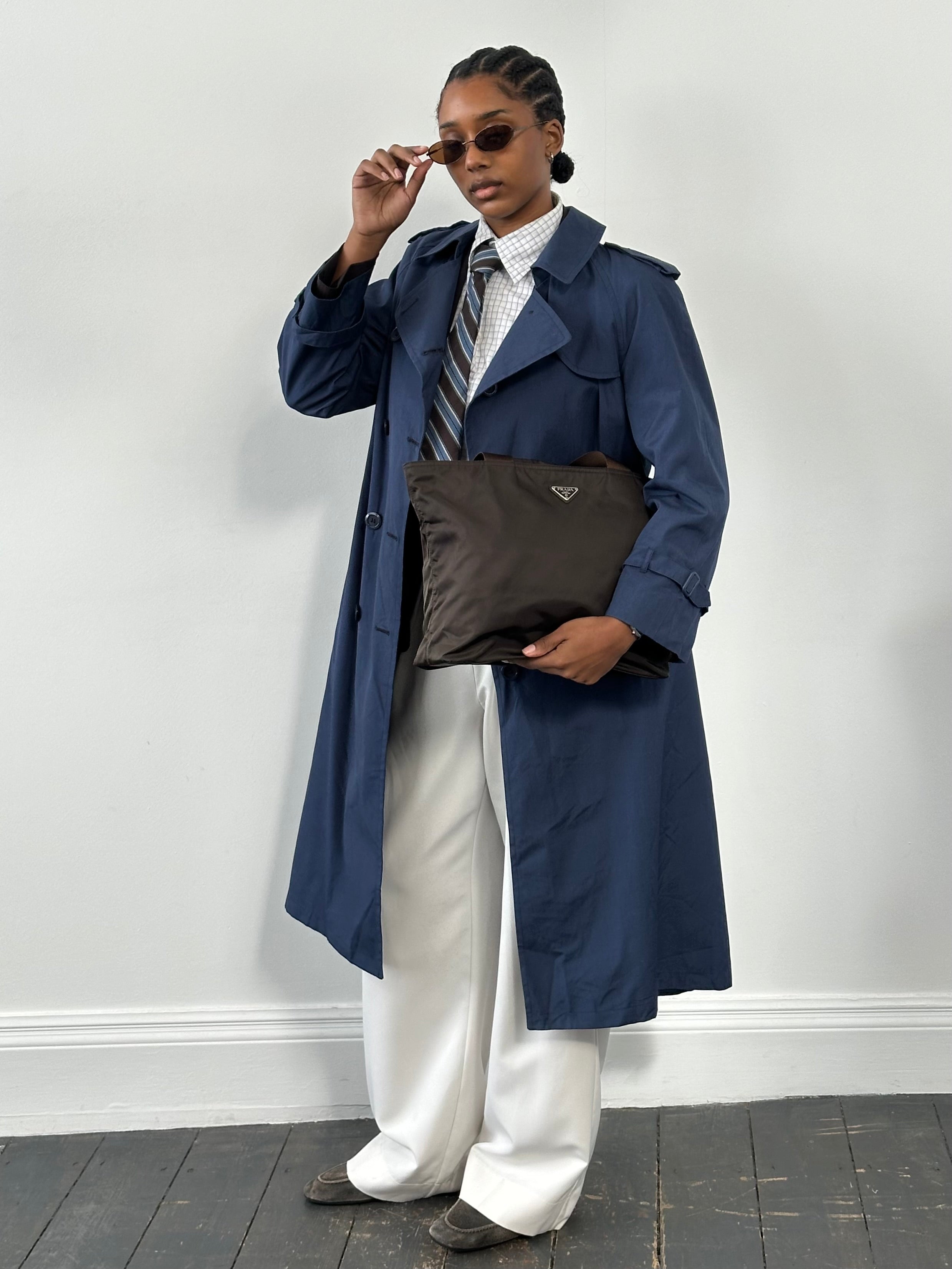London Fog 1990s double-breasted cotton trench coat in size S/M, shown hanging with classic design and belt details.